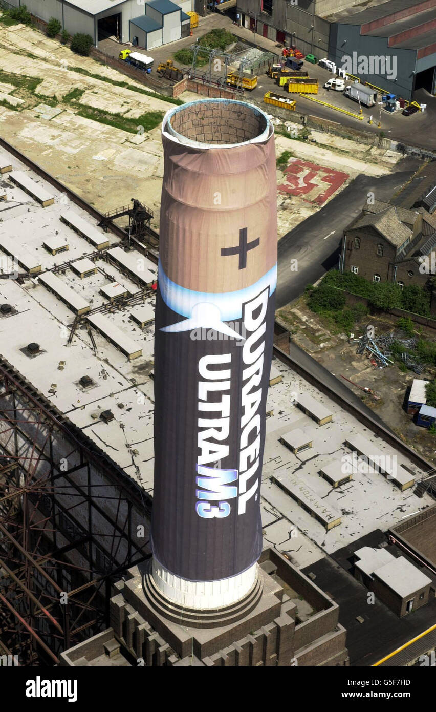 Le lancement du nouveau Duracell Ultra M3, en cours à la centrale électrique de Battersea, à Londres. Malgré les retards dus à des conditions météorologiques extrêmes, comme des vents allant jusqu'à 55 km/h, l'équipe de Duracell a obtenu la première couverture de 40 m au-dessus d'une cheminée. *...l'équipe prévoit de placer quatre couvertures de 40m de haut portant le nouveau marquage de produit sur les quatre cheminées de la centrale électrique en utilisant des grues géantes. Banque D'Images