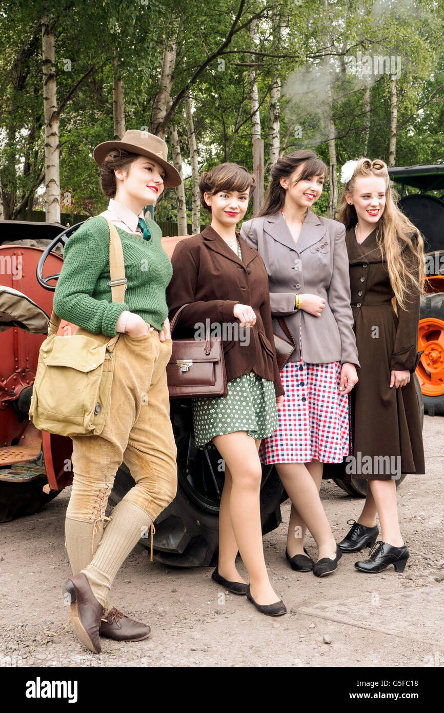 Les jeunes femmes posant dans des vêtements des années 1940. Fille sur la gauche est une jeune fille des terres, d'autres jeunes personnes typique en robe. NB Re-enactment. Banque D'Images