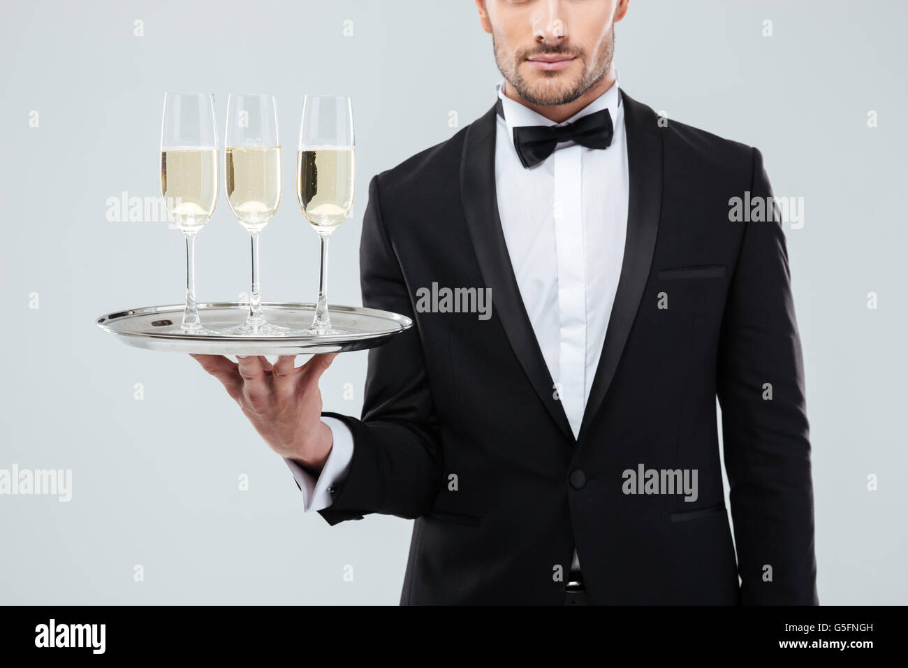 Libre de serveurs en smoking et noeud papillon holding tray with glasses of  champagne Photo Stock - Alamy