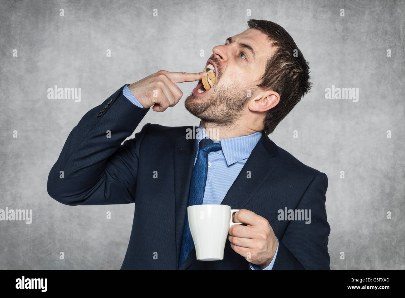 Businessman animaux un sandwich dans sa bouche Banque D'Images