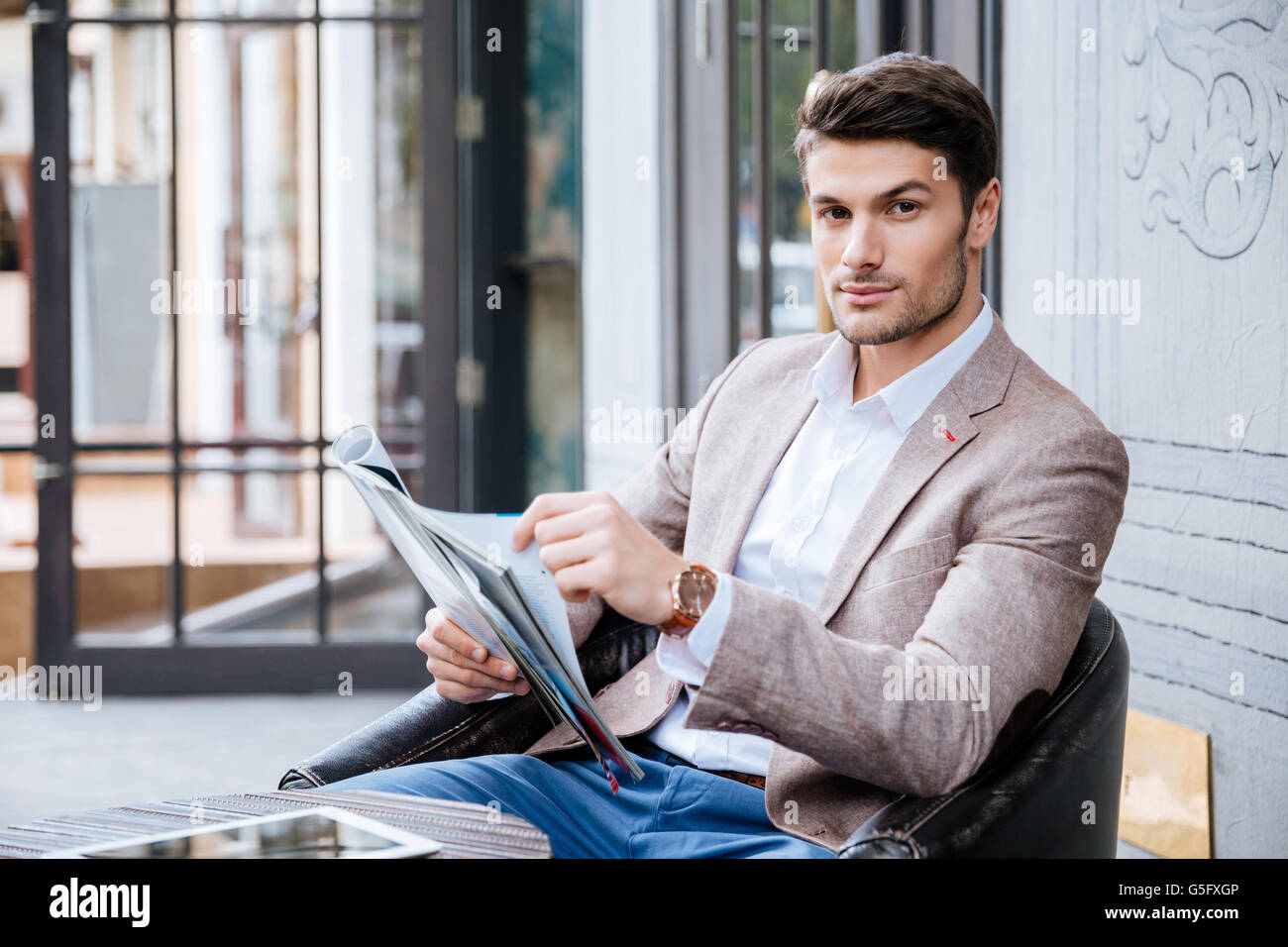 Attractive businessman en costume est assis à table dans un café en plein air Banque D'Images