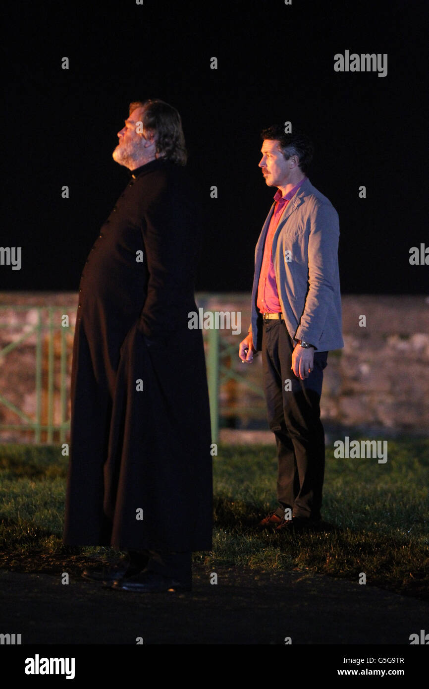 Brendan Gleeson (à gauche) et Aidan Gillen sur la scène du nouveau film irlandais « Calvary » à Rush, au Co.Dublin, alors que des centaines de personnes locales se sont avéré regarder filmer comme une église factice a été incendiée dans le village. Banque D'Images