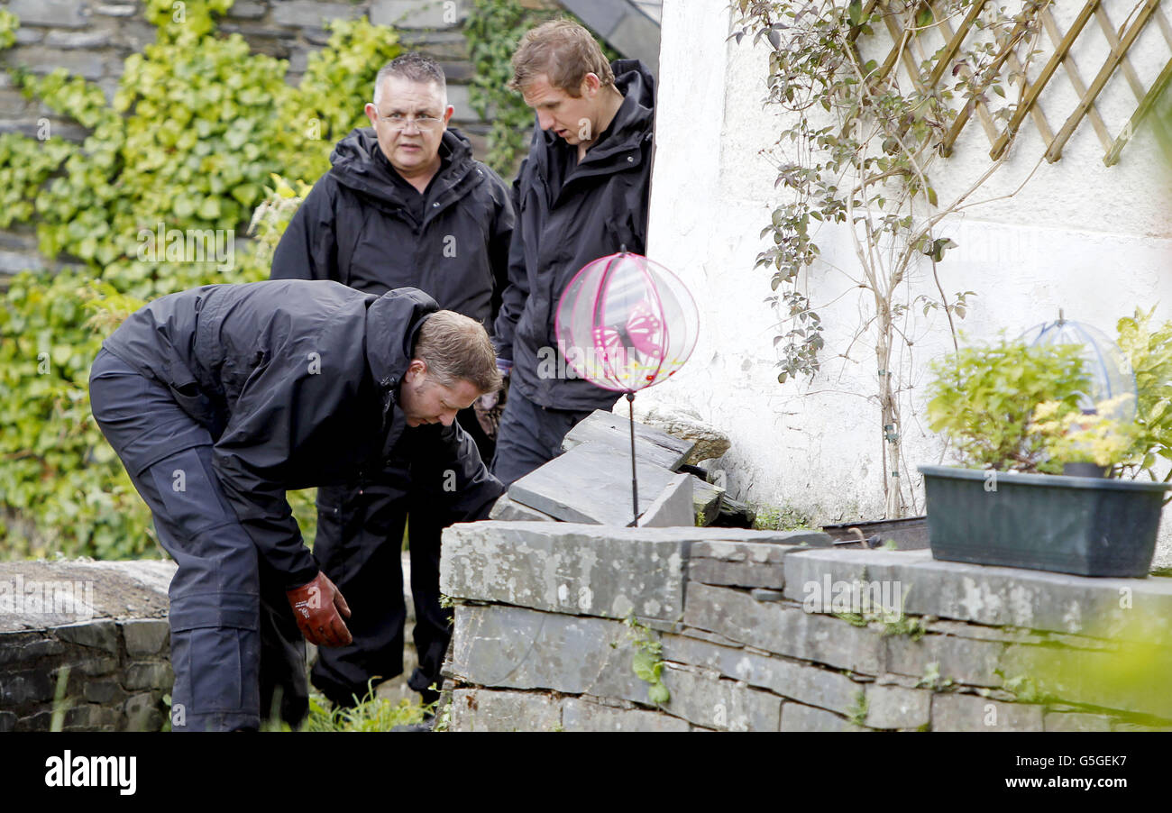 Des policiers gallois foutent devant une maison du nom de Mount Pleasant dans le village de Ceinws, considéré comme la dernière résidence de Mark Bridger, suspect dans l'enlèvement d'avril Jones. Banque D'Images