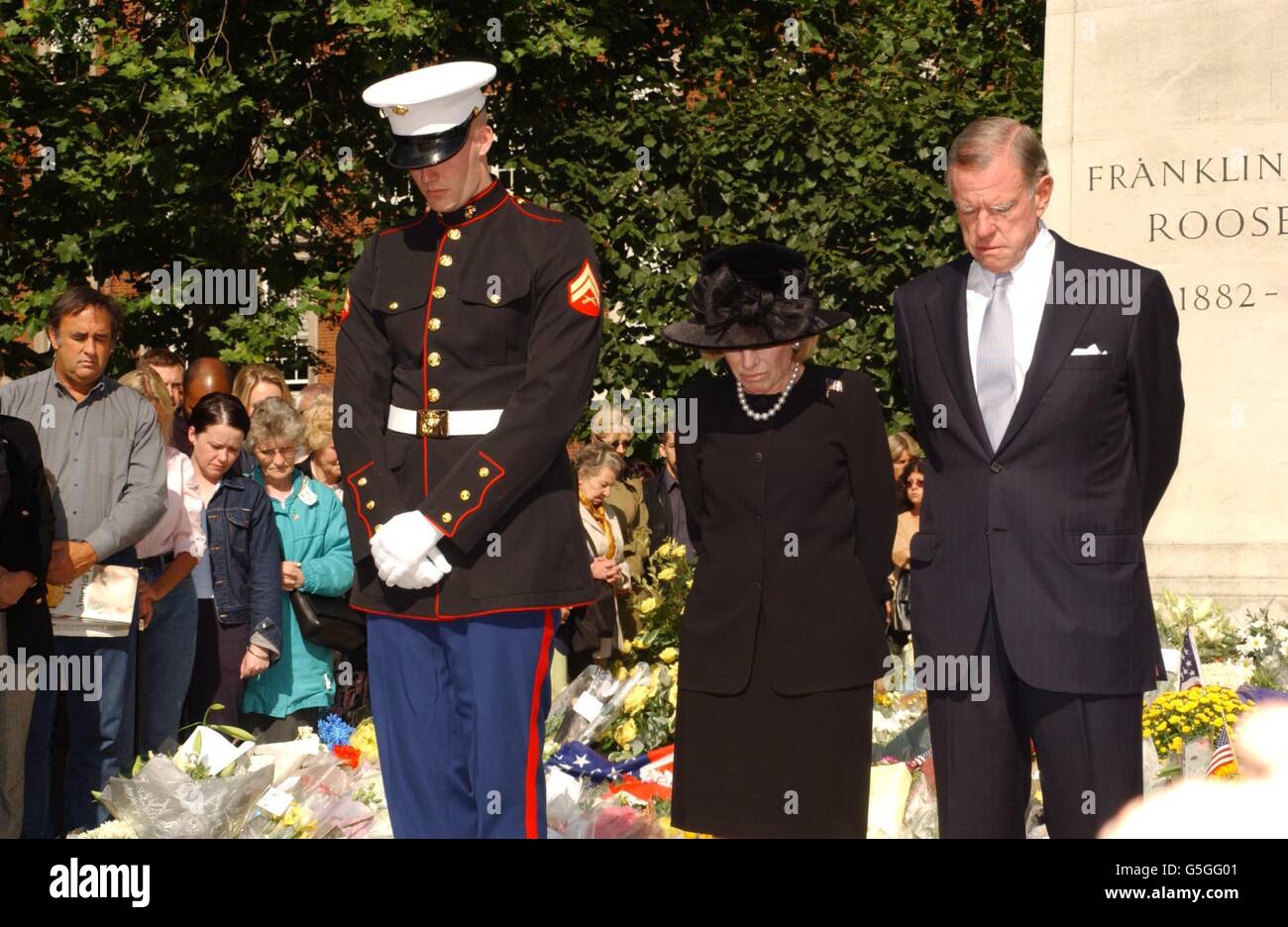 L’ambassadeur DES ÉTATS-UNIS William Farish (à droite), son épouse et un soldat américain observent un silence de trois minutes en souvenir de ceux qui sont morts lors des récents attentats terroristes contre l’Amérique, au Roosevelt Memorial de Grosvenor Square, dans le centre de Londres. Banque D'Images