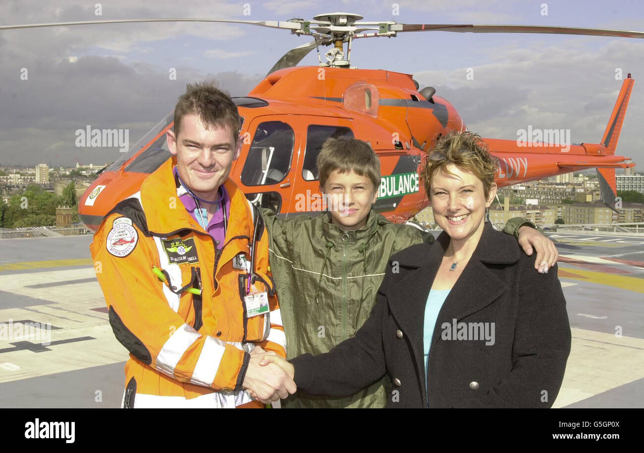 Debout avec sa mère Sue, le garçon de 12 ans Sam Munden, qui était à quelques minutes de la mort après avoir traversé la glace d'un étang, rencontrant son sauveteur, le major Malcolm Russell, sur l'héliport de l'hôpital Royal London. * ...pour la première fois depuis que le major Russell, un médecin de l'armée, l'a sorti de l'étang est de Londres. La réunion devait marquer l'annonce que le major Russell a remporté une nomination de personnes de l'an 2001 par l'Association royale pour l'invalidité et la réadaptation (RADAR). Banque D'Images