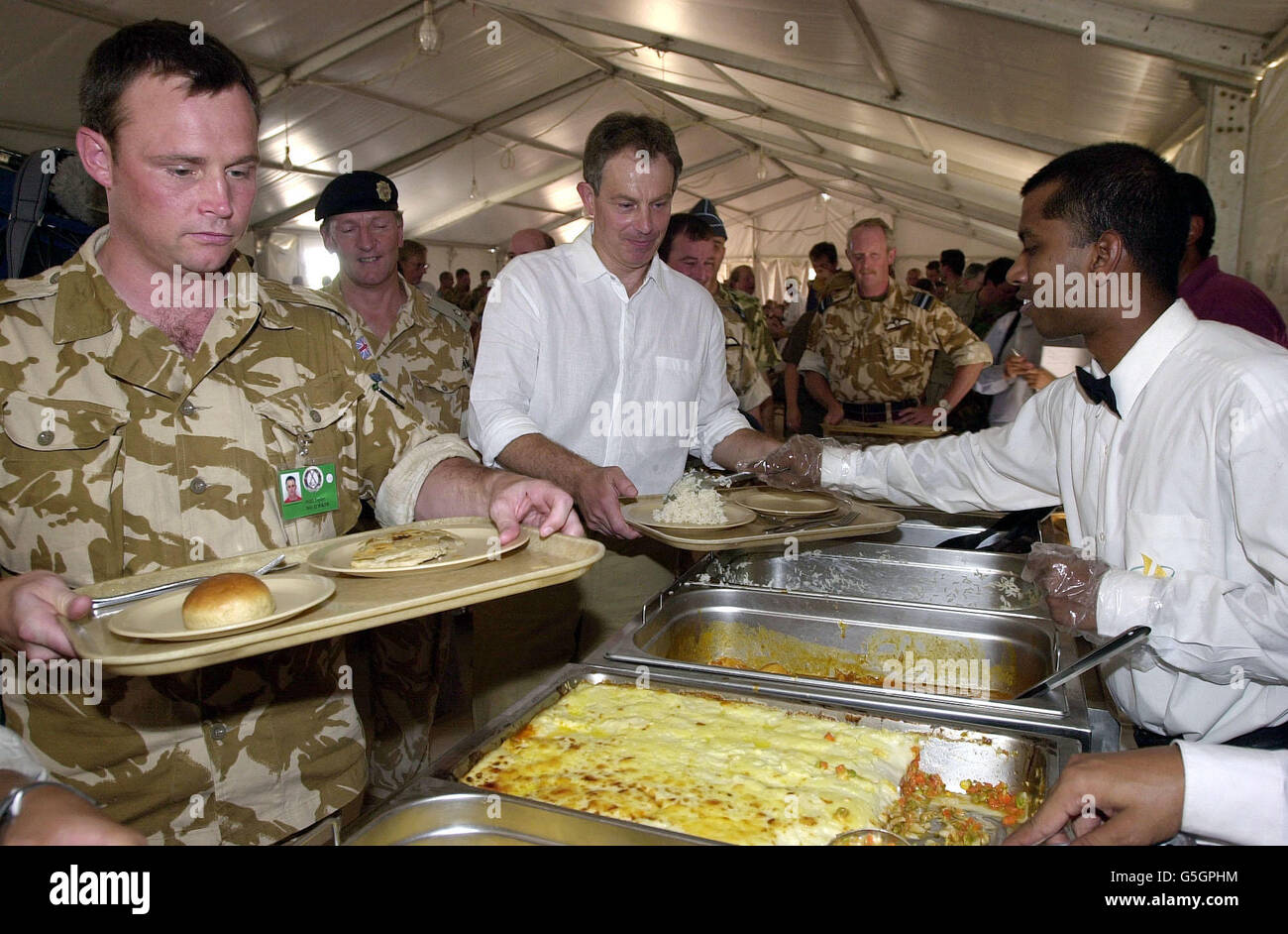 Le Premier ministre britannique Tony Blair rend visite aux troupes britanniques en cours d'exercice à Oman. M. Blair s'est joint aux troupes dans un mess de fortune pour un déjeuner de curry, de riz et de pois lors d'une visite de la base Al Sha'afa, le centre de commandement de l'opération Swift Sword II *, impliquant plus de 20,000 militaires britanniques dans le plus grand déploiement depuis la guerre du Golfe. Banque D'Images