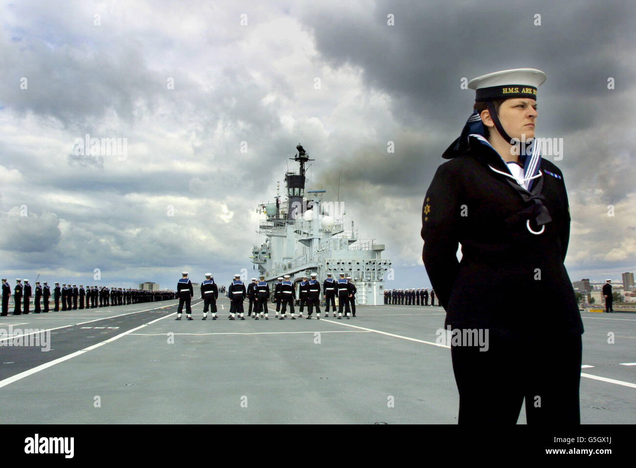 L'équipage du porte-avions de la Royal Navy HMS Ark Royal est à l'attention sur le pont de vol alors qu'elle navigue dans le port de Portsmouth après deux ans de rénovation majeure à Rosyth, en Écosse. L'Ark Royal sera entièrement opérationnel l'année prochaine. L'Ark Royalhas a passé les deux dernières années et demie à être modernisé pour prendre à bord des nouveaux hélicoptères anti-sous-marins Merlin de la marine, ainsi que pour être en mesure d'exploiter des Seakings, des marins et des harrieurs RAF. Voir PA Story DEFENSE ArkRoyal. Photo PA: Peter J Jordan. Banque D'Images