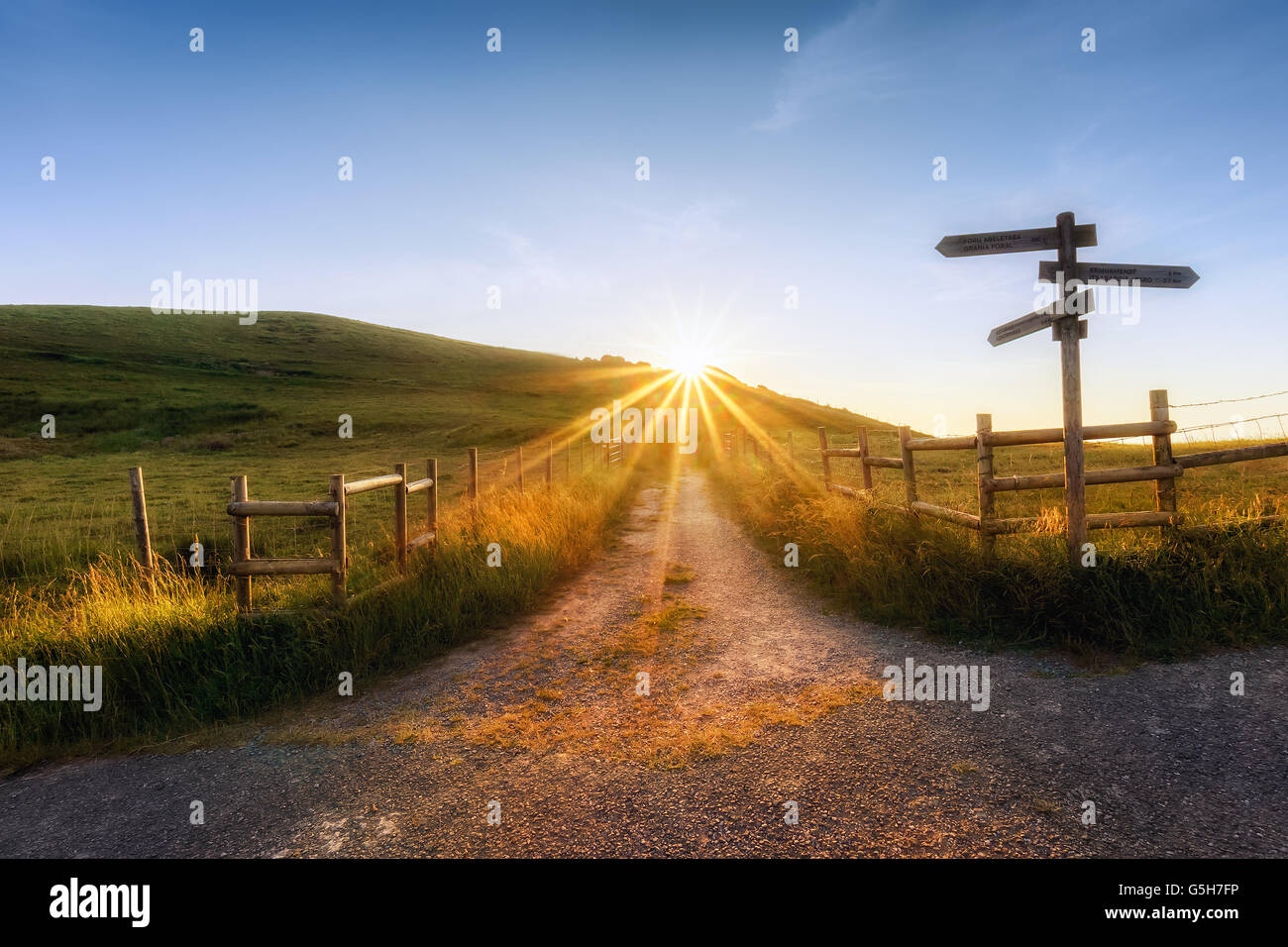 Panneau en bois à proximité d'un chemin et le soleil Banque D'Images