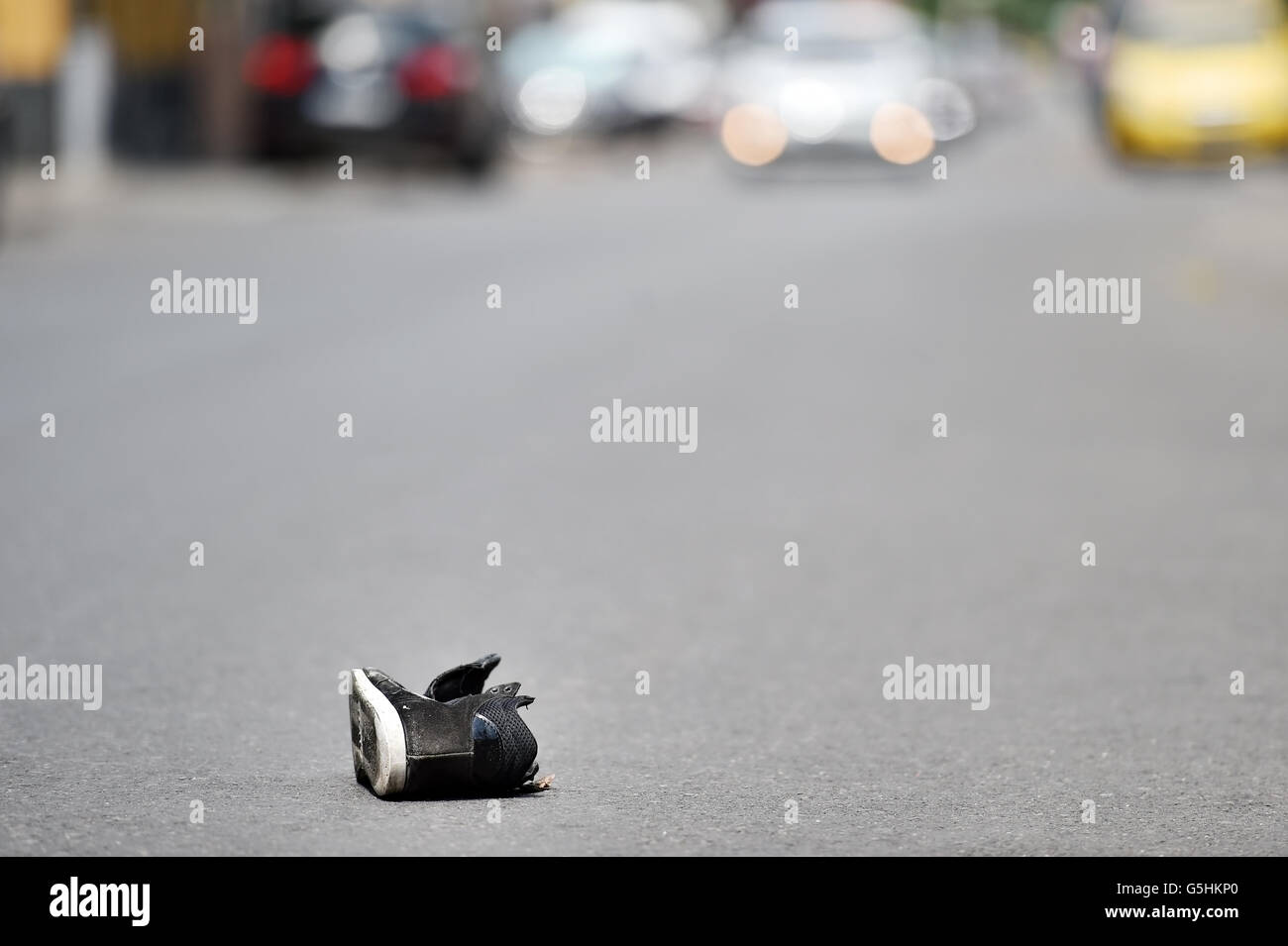 Ses chaussures dans la rue avec des voitures en arrière-plan après victime a été heurté par le véhicule Banque D'Images
