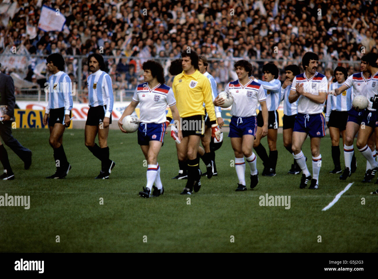 1980: L'équipe de football d'Angleterre marchant sur le terrain à Wembley pour l'ami contre les champions du monde Argentine.Kevin Keegan (balle de maintien) mène, de gauche à droite, Ray Clemence, Kenny Sansom et David Johnson (moustache). Banque D'Images