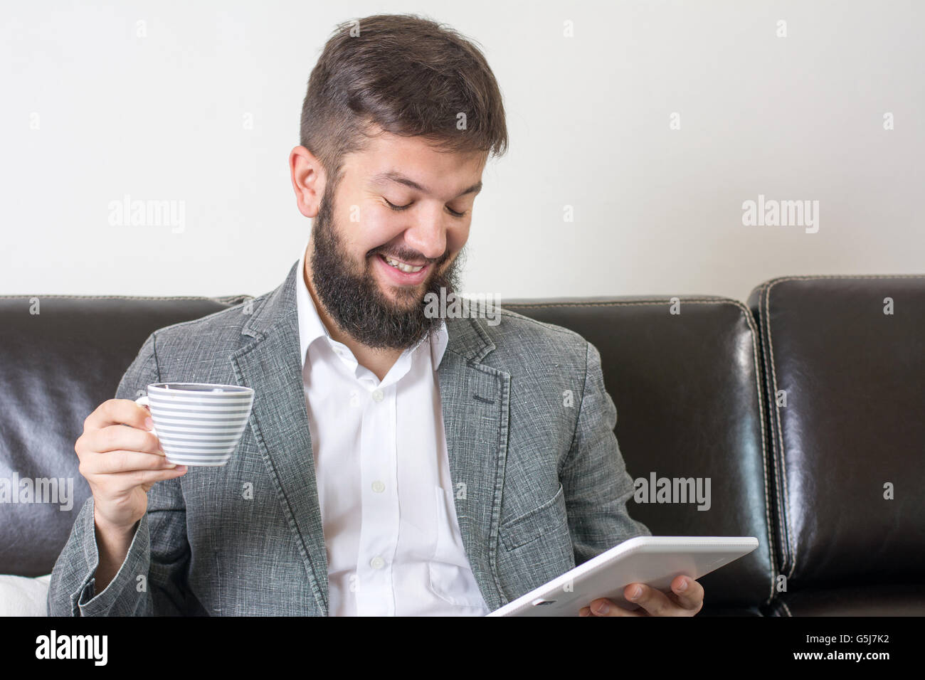 Businessman reading news avec une tasse de café Banque D'Images