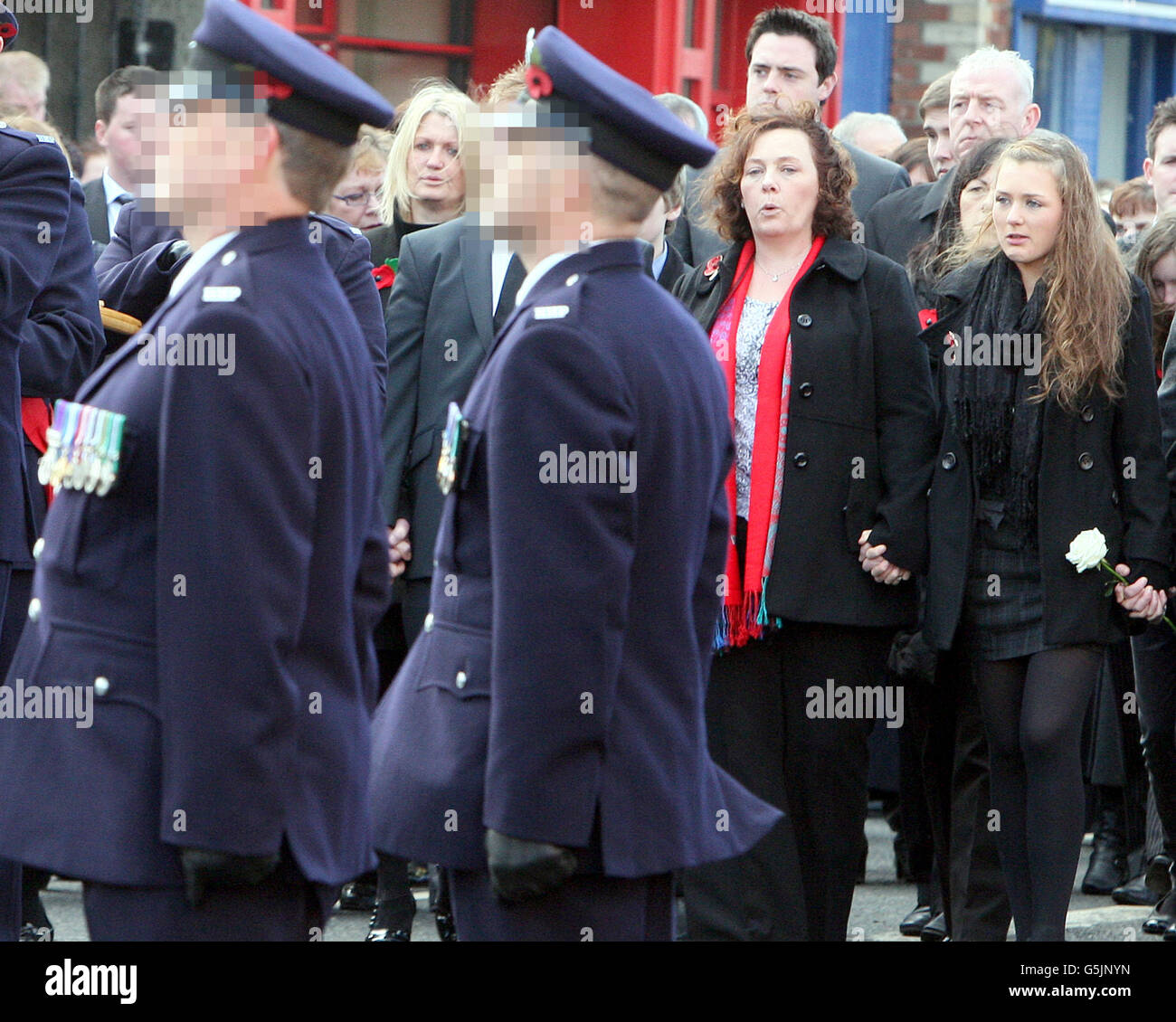 LES OFFICIERS DE PRISON FONT FACE À DES PIXÉLISÉS À LA DEMANDE DU SERVICE PÉNITENTIAIRE D'IRLANDE DU NORD Yvonne Black, veuve de l'agent pénitentiaire assassiné David Black, avec sa fille Kyra, qui marche derrière son cercueil alors qu'il arrive à l'église presbytérienne de Molesworth, dans sa ville natale de Cookstown, à Co Tyrone. Banque D'Images