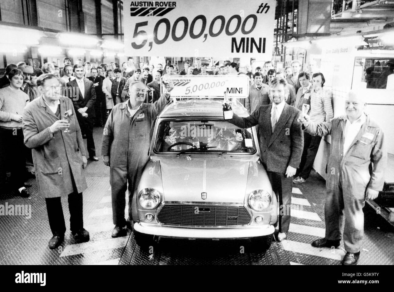 La star de la télévision Noel Edmonds rejoint les employés d'Austin Rover pour une célébration du champagne et toaster une nouvelle star : le 5 000ème mini-voiture à sortir de la chaîne de production de Longbridge. M. Edmonds est président de l'organisation Stars for Spastics, à qui la voiture est donnée. Banque D'Images
