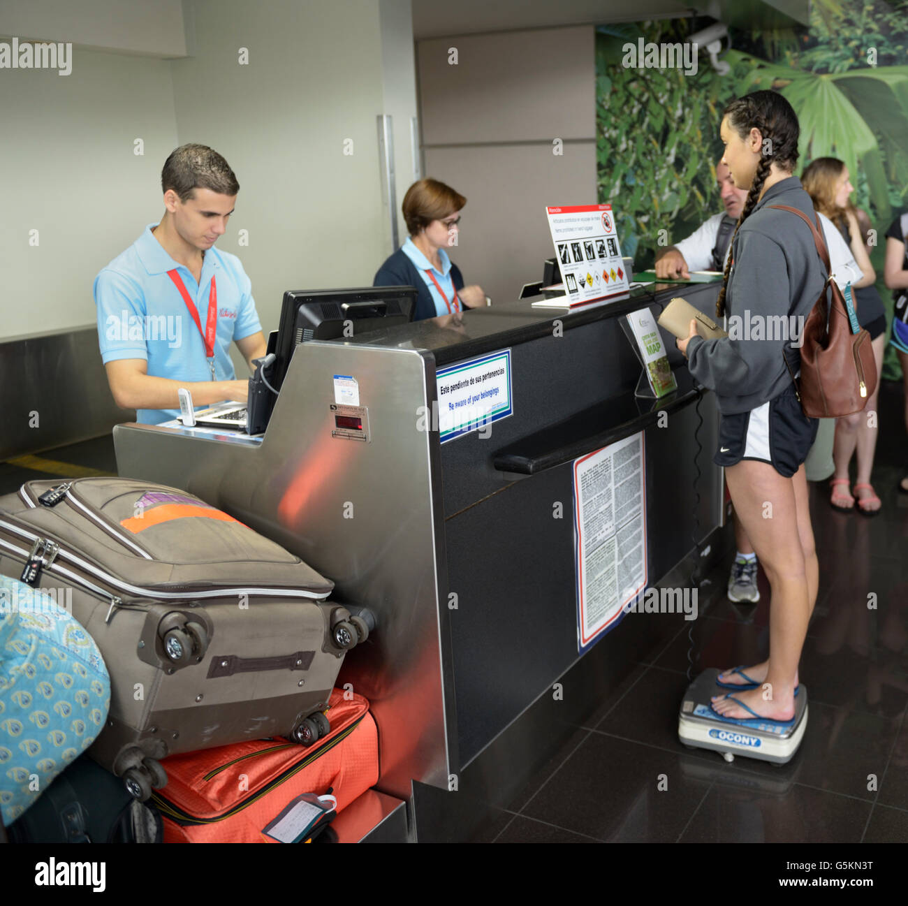 Pesée de voyageur et de bagages à l'aéroport avant l'embarquement petit avion, San Jose, Costa Rica Banque D'Images