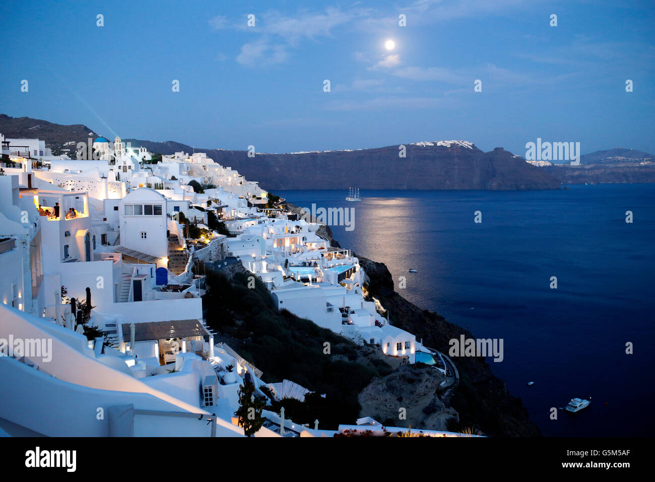 Pleine lune sur l'île de Santorin dans les Cyclades et la phosphorescence (dans la mer), Grèce Banque D'Images