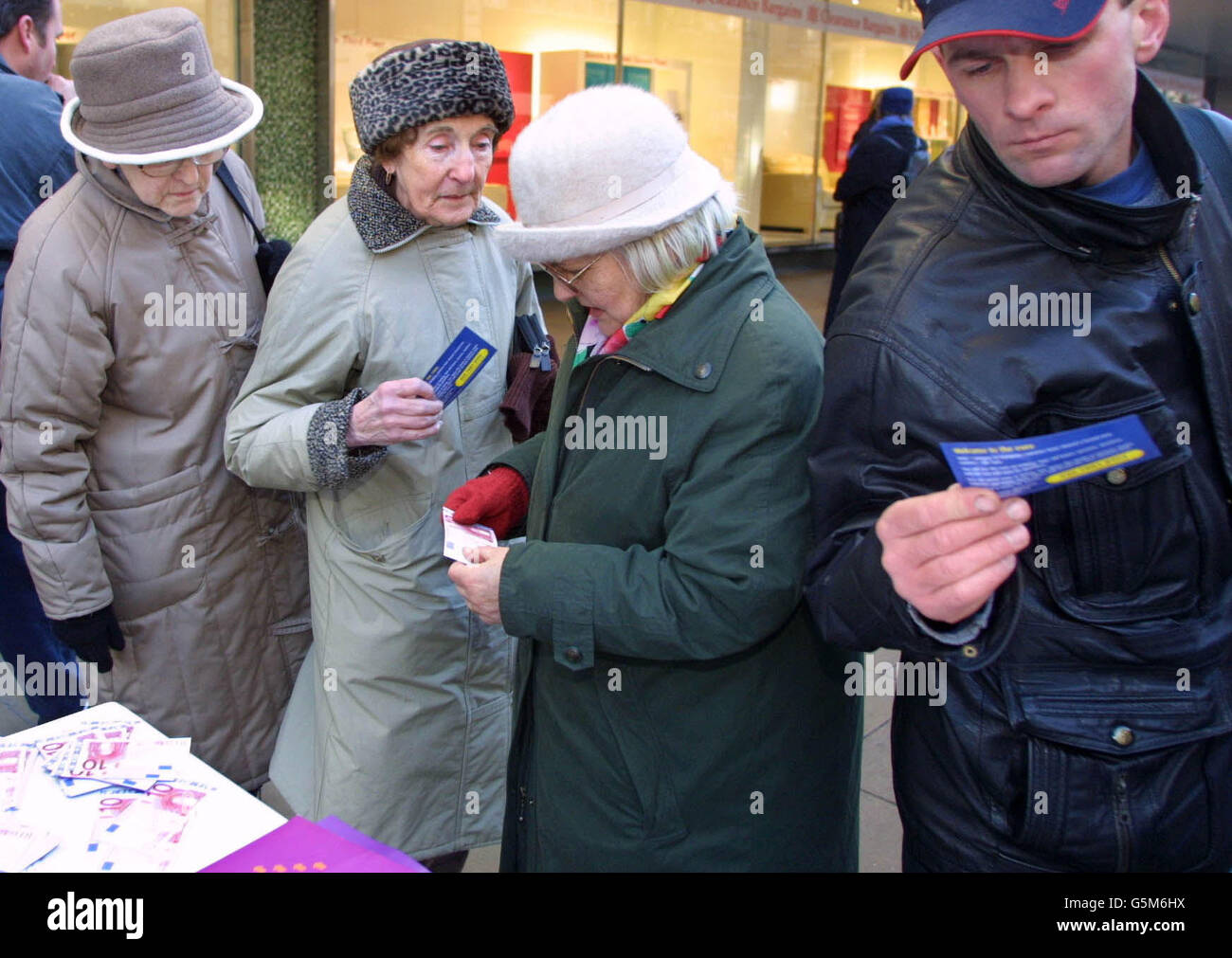 Les passants regardent des prélèvements sur des billets de banque en euros dans une cabine mise en place par le groupe Pro-Euro « Britain in Europe » sur Oxford Street à Londres. L'euro, la monnaie de l'Union européenne, est devenu monnaie légale ce matin. * la Grande-Bretagne est le seul pays de l'Union européenne qui n'a pas adopté la nouvelle monnaie comme sa propre, mais beaucoup de magasins dans tout le pays accepteront les notes. Banque D'Images