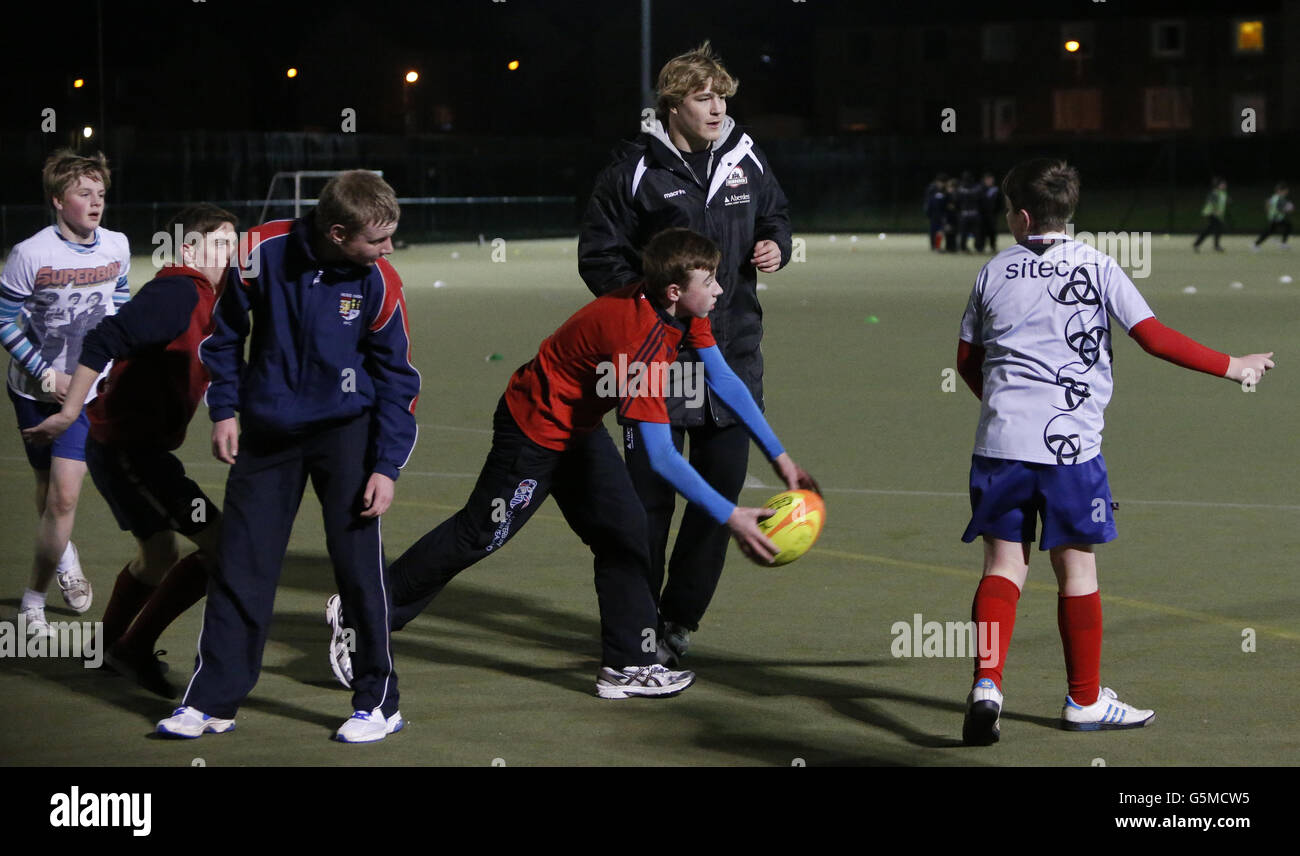 David Denton d'Edinburgh Rugby avec des enfants de l'école secondaire Ross lors d'une journée de rugby à tête noire où des membres de l'équipe de joueurs ont donné des séances de rugby aux enfants de l'école, à Ross High, East Lothian. Banque D'Images