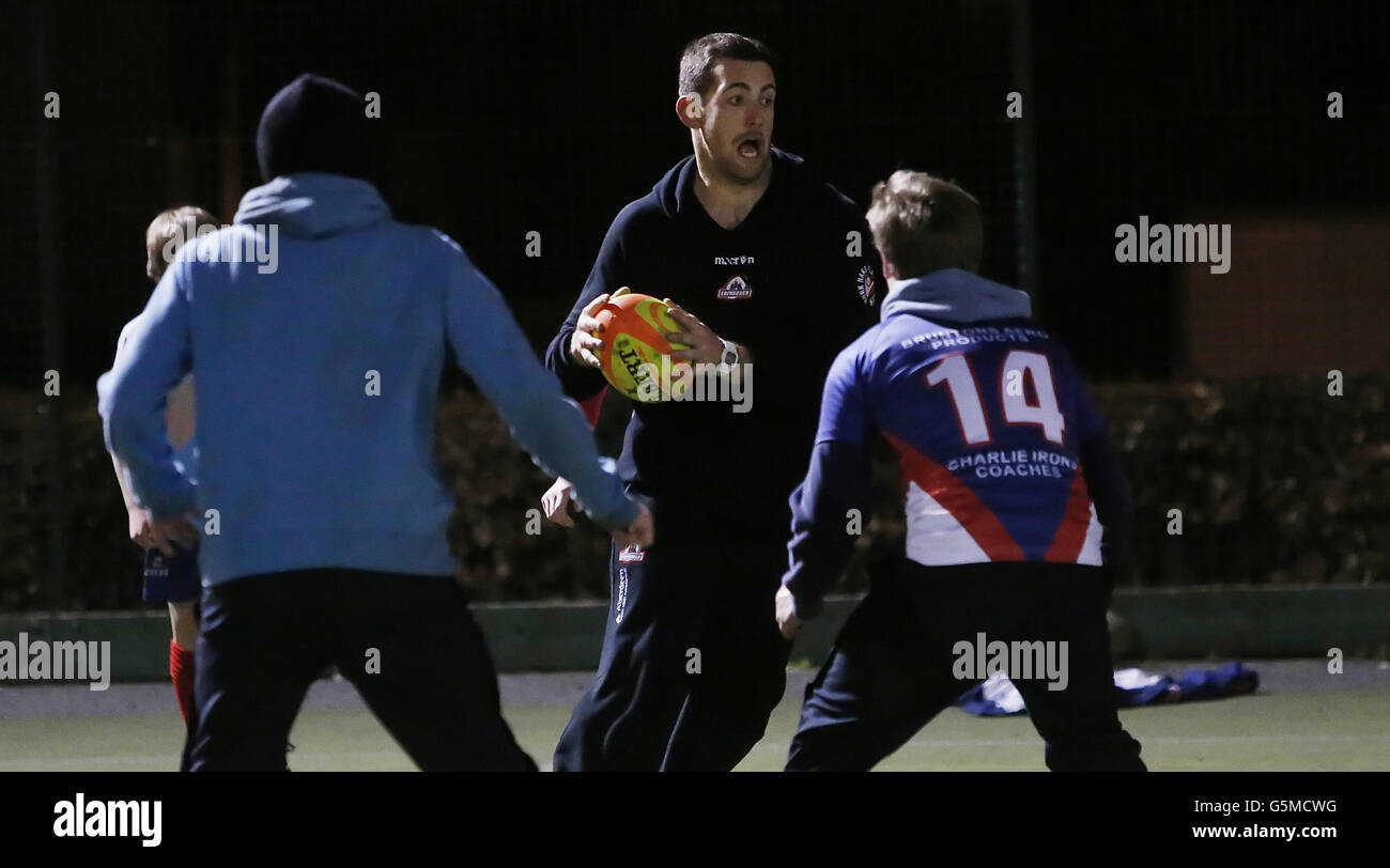 Perry Parker d'Edinburgh Rugby avec des enfants de l'école secondaire Ross lors d'une journée de rugby à tête noire où des membres de l'équipe de joueurs ont donné des séances de rugby aux enfants de l'école, à Ross High, East Lothian. Banque D'Images