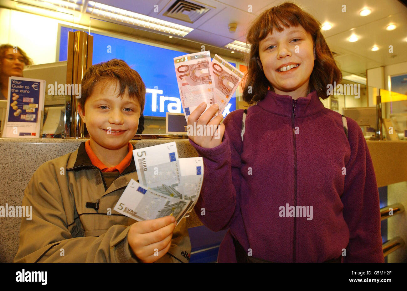 William Sharpley, huit ans, d'Oxford, et sa sœur Holly, 11 ans, détiennent les nouveaux billets en euros qu'ils ont achetés à un bureau de change Travelex à l'aéroport de Londres Heathrow avant d'embarquer pour un vol à destination de Rome. * plus de 300 millions de résidents dans les pays européens se sont réveillés en utilisant la nouvelle monnaie. La Grande-Bretagne, le Danemark et la Suède n'ont pas adhéré à la nouvelle monnaie, mais plusieurs grands détaillants ont déclaré qu'ils accepteraient cette monnaie de la part de leurs clients. Banque D'Images