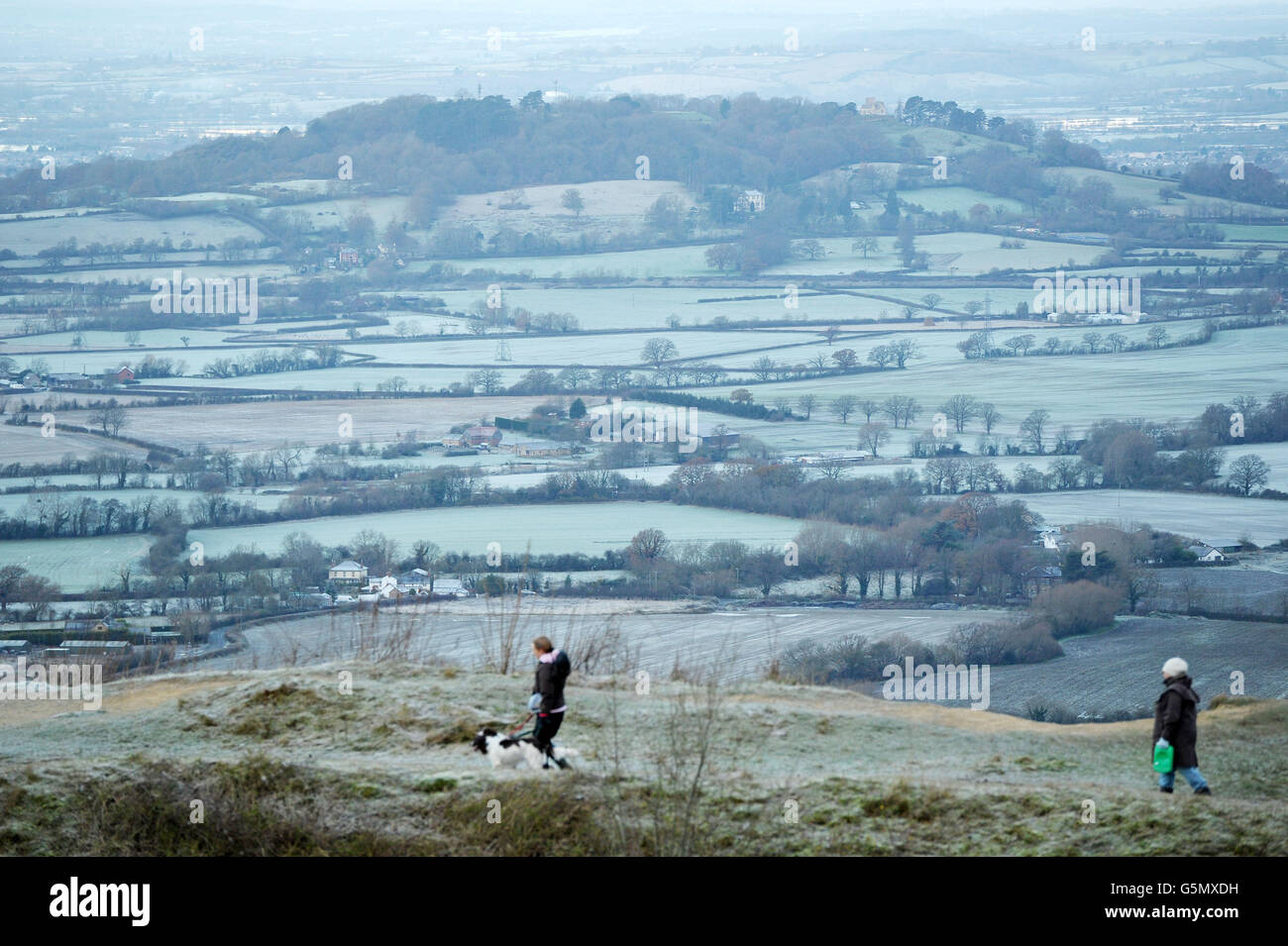 Les gens marchent leurs chiens au Crickley Hill Country Park tout en surpassant les terres agricoles glacées autour de Gloucester, alors que le temps froid balaie le Royaume-Uni avec de la neige attendue ce soir. Banque D'Images