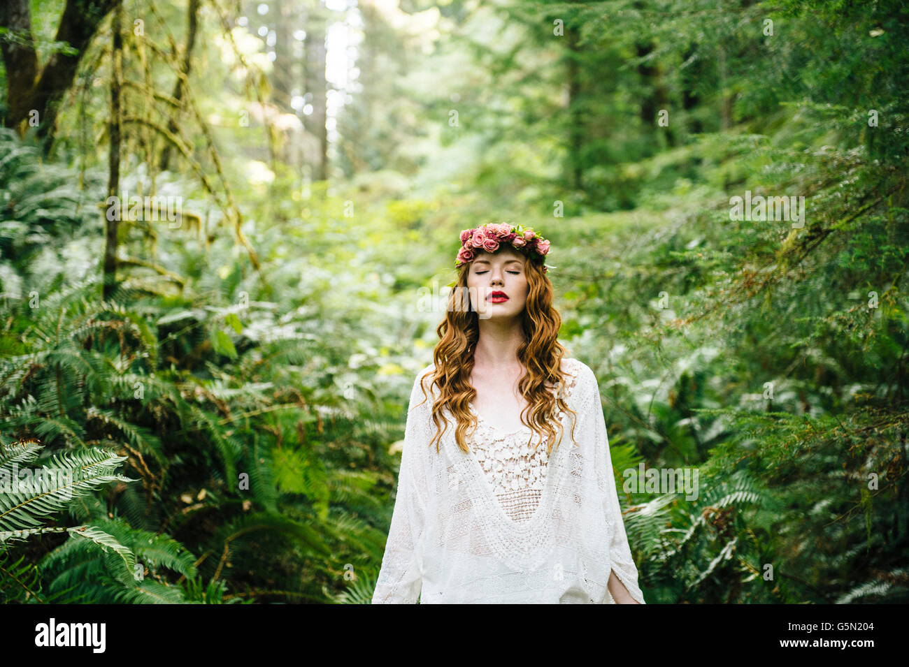 Caucasian woman wearing flower crown in forest Banque D'Images