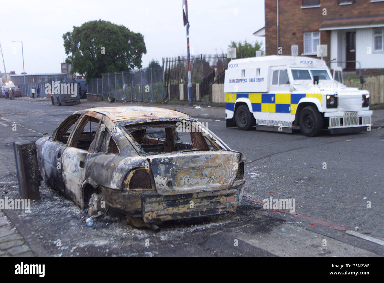 Une voiture de police brûlée sur la route Ardoyne après des émeutes dans la région la nuit dernière à Belfast. Une rangée de sentiers entre deux mères a déclenché la nouvelle flambée de violence sectaire qui a éclaté au point d'éclair nord de Belfast, a déclaré la police. * les officiers ont déménagé pour briser une confrontation après qu'une mère catholique sur son chemin pour recueillir sa fille de l'école primaire de Sainte Croix a été contestée par une femme protestante. C'est alors que des ennuis ont éclaté, se torgeant dans le pire désordre de rue de Belfast pendant plusieurs mois. Banque D'Images