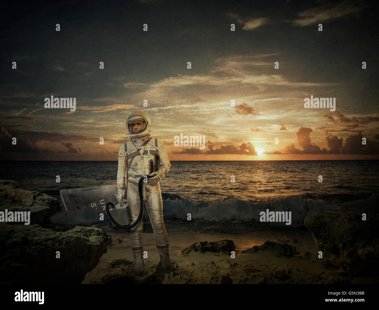 L'astronaute caucasienne standing on beach at sunset Banque D'Images