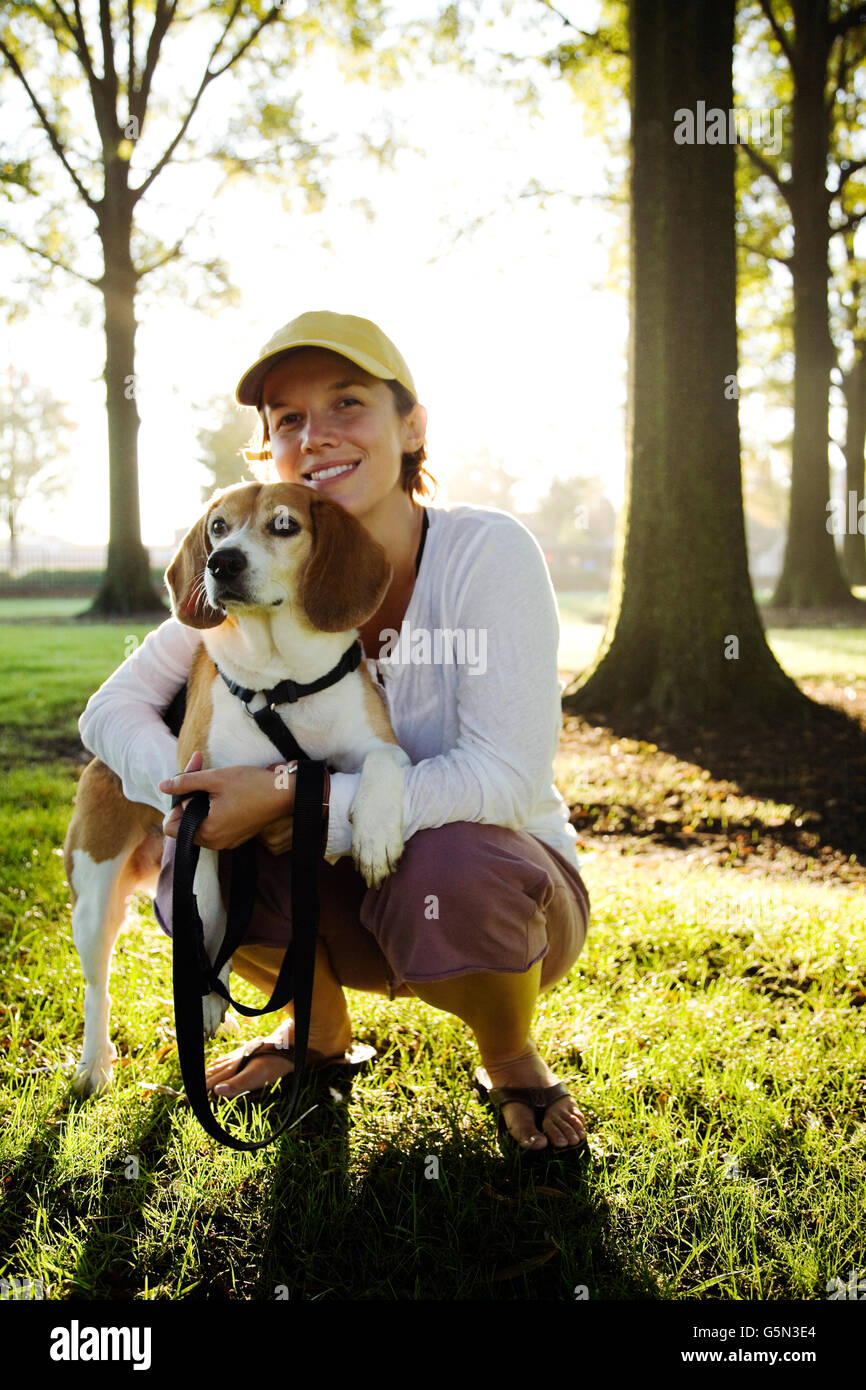 Caucasian woman hugging dog in park Banque D'Images