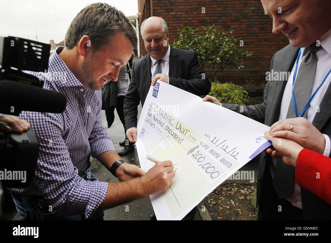 Le golfeur Graham McDowell signe un chèque géant de 200,000 euros pour l'unité cardiaque de l'hôpital pour enfants Crumlin à Dublin lors de sa visite à l'hôpital aujourd'hui. Banque D'Images