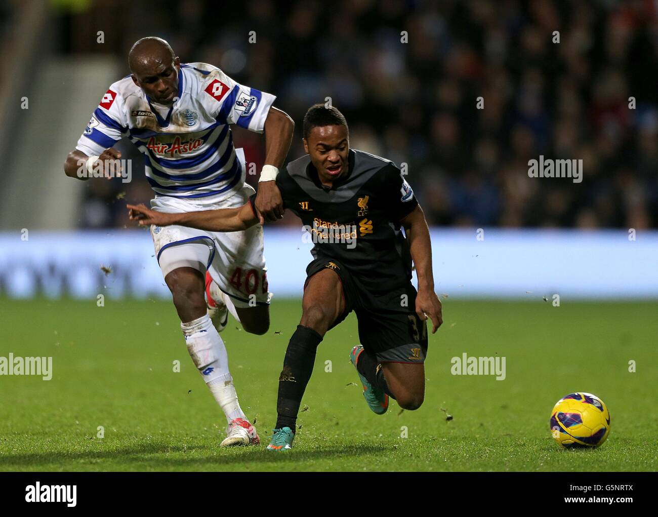 Soccer - Barclays Premier League - Queens Park Rangers v Liverpool - Loftus Road.Stephane Mbia (à gauche) des Queens Park Rangers et Raheem Sterling de Liverpool pour le ballon Banque D'Images