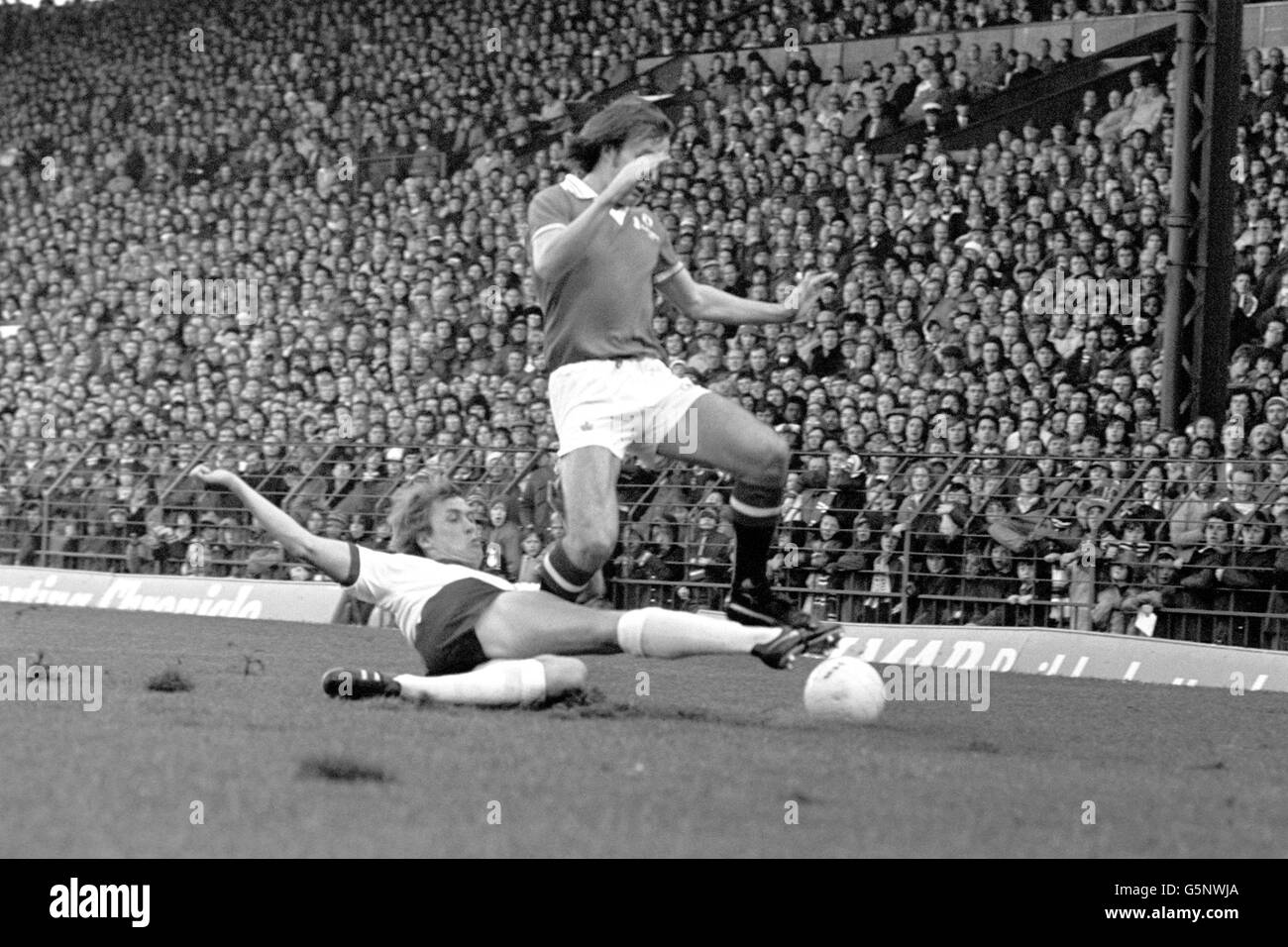 Un équipement de glisse de Phil Neal de Liverpool croque Sammy McIlroy, de Manchester United, du ballon lors du match de première division à Old Trafford. Banque D'Images