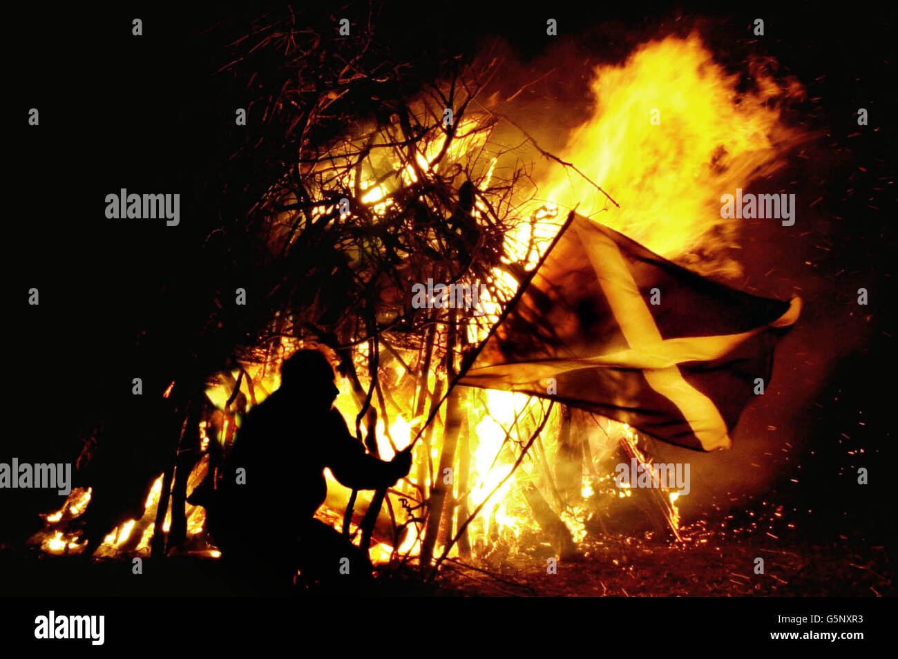 Allan Murray, directeur de la Scottish Countryside Alliance et quelques manifestants à Édimbourg, branle un drapeau écossais après avoir allumé un phare et il en a été de même à Glasgow pour montrer leur opposition généralisée au vote final du projet de loi sur la protection des animaux sauvages (Écosse) du Parlement écossais. Banque D'Images