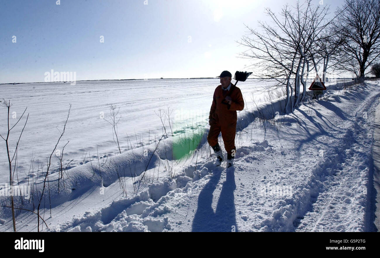 La neige est presque au même niveau que les sommets des murs de champ, alors qu'un agriculteur sur les collines au-dessus de Thirsk dans le North Yorkshire s'est rendu au travail après de fortes chutes de neige au début. Banque D'Images