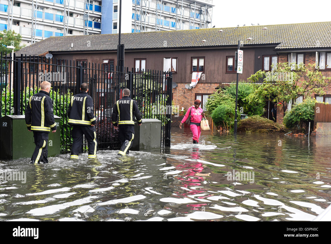 Londres, Royaume-Uni. 23 juin 2016. Fortes pluies à l'origine des inondations dans l'Est de Londres, Canning Town. Trois pompiers et d'un résident local pataugeant dans la route inondée. Credit : ZEN - Zaneta Razaite / Alamy Live News Banque D'Images