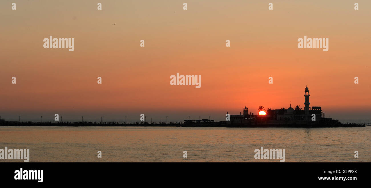 Le soleil se couche derrière la mosquée Haji Ali Dargah à Mumbai qui a récemment interdit aux femmes d'entrer dans le sanctuaire (lieu de repos du saint) Inde PRESSE ASSOCIATION photo. Date de la photo : vendredi 23 novembre 2012. Les femmes peuvent maintenant offrir des prières et chadar de derrière une barrière à quatre pieds du mazaar (tombe), les empêchant ainsi de toucher le lieu de repos du saint. Le crédit photo devrait se lire: Anthony Devlin/PA Banque D'Images