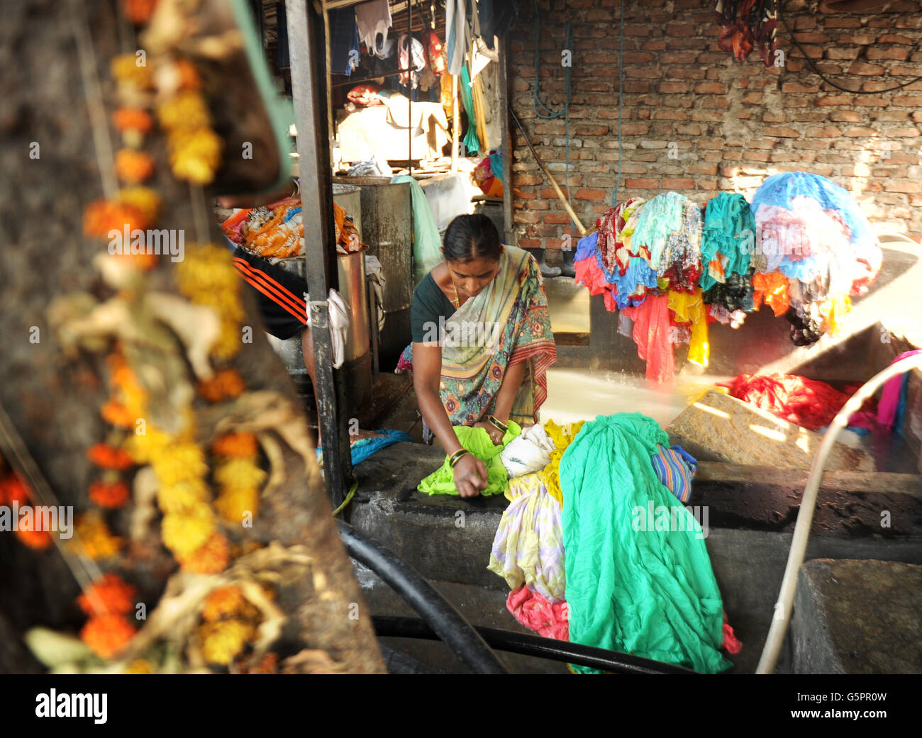 Les lave-linge, connus localement sous le nom de Dhobis, travaillent à l'ouverture pour laver les vêtements des ménages, des hôtels et des hôpitaux de Mumbai au Mahalaxmi Dhobi Ghat (lieu de lavage) dans le district de Mahalaxmi de Mumbai, Inde PRESS ASSOCIATION photo. Date de la photo: Mardi 27 novembre 2012. Généralement une profession héréditaire environ 200 familles dhobi du Vannar un groupe de castes vivent et travaillent ici et opèrent habituellement de porte à porte collectant le linge sale des ménages, des hôpitaux et des hôtels. Pour éviter que les vêtements ne soient mélangés, chaque dhobi marque un symbole ou un caractère unique à l'encre noire sur les vêtements appartenant Banque D'Images