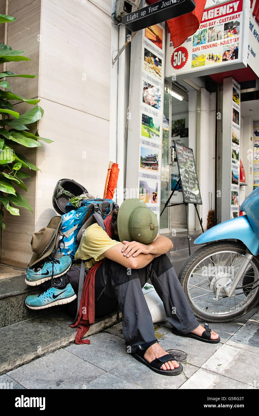 Un randonneur repose sur les étapes d'une boutique dans le vieux quartier de Hanoi, le lac Hoan Kiem, au Vietnam. Banque D'Images
