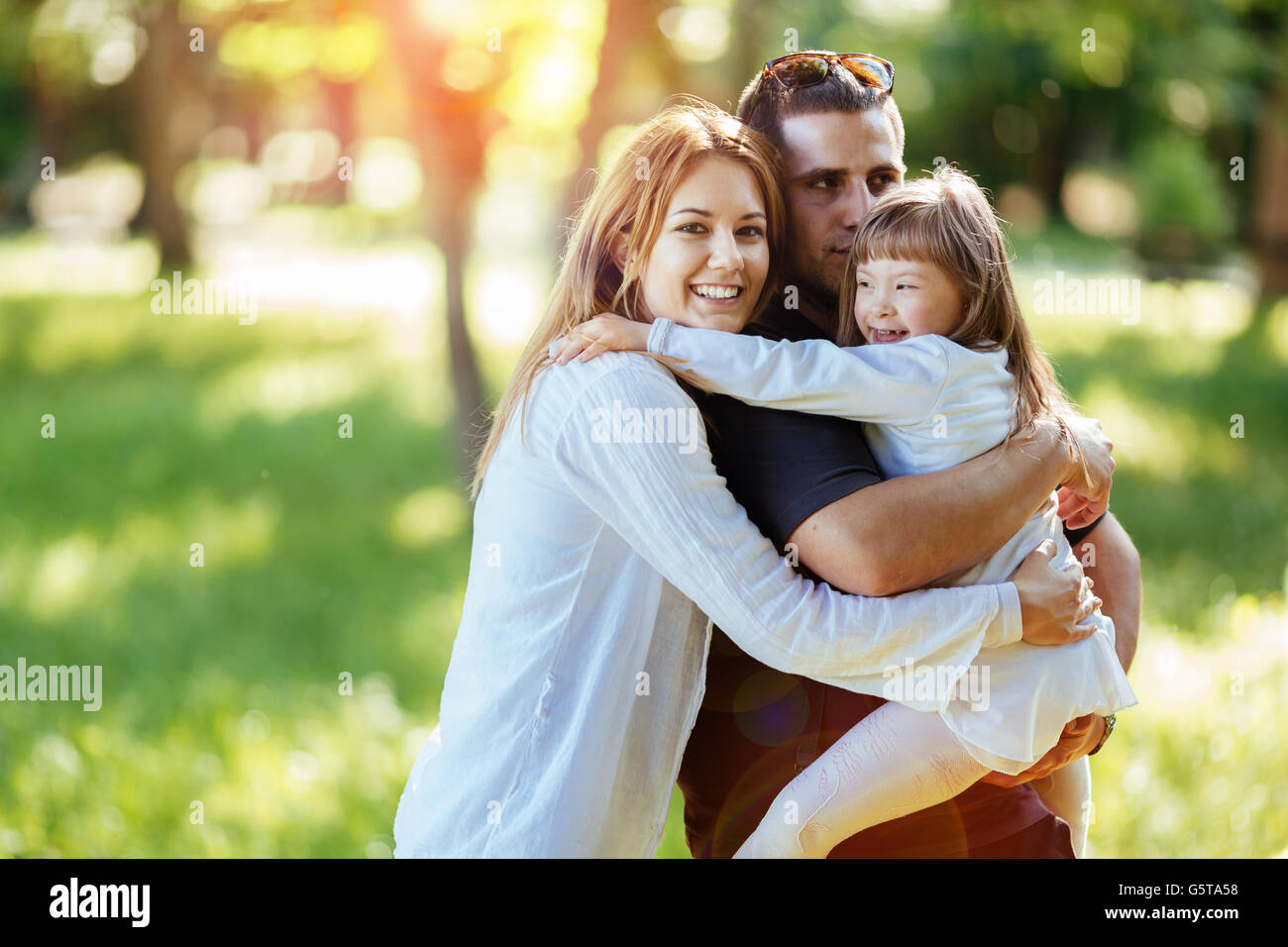 Famille heureuse à l'extérieur avec un enfant adopté né avec le syndrome de Banque D'Images