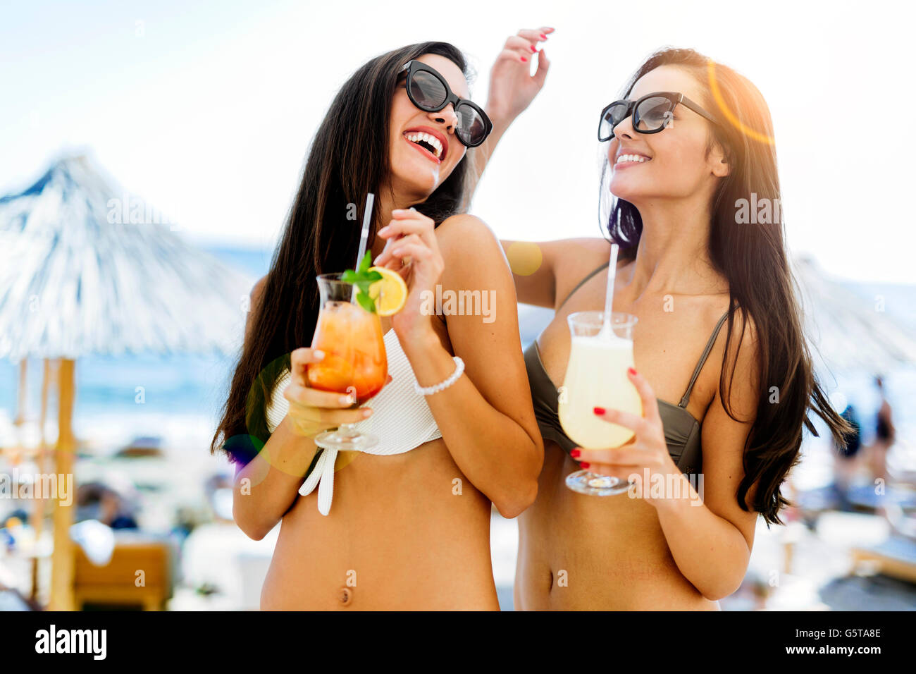 Cheerful female friends la fête sur la plage en bikini Banque D'Images