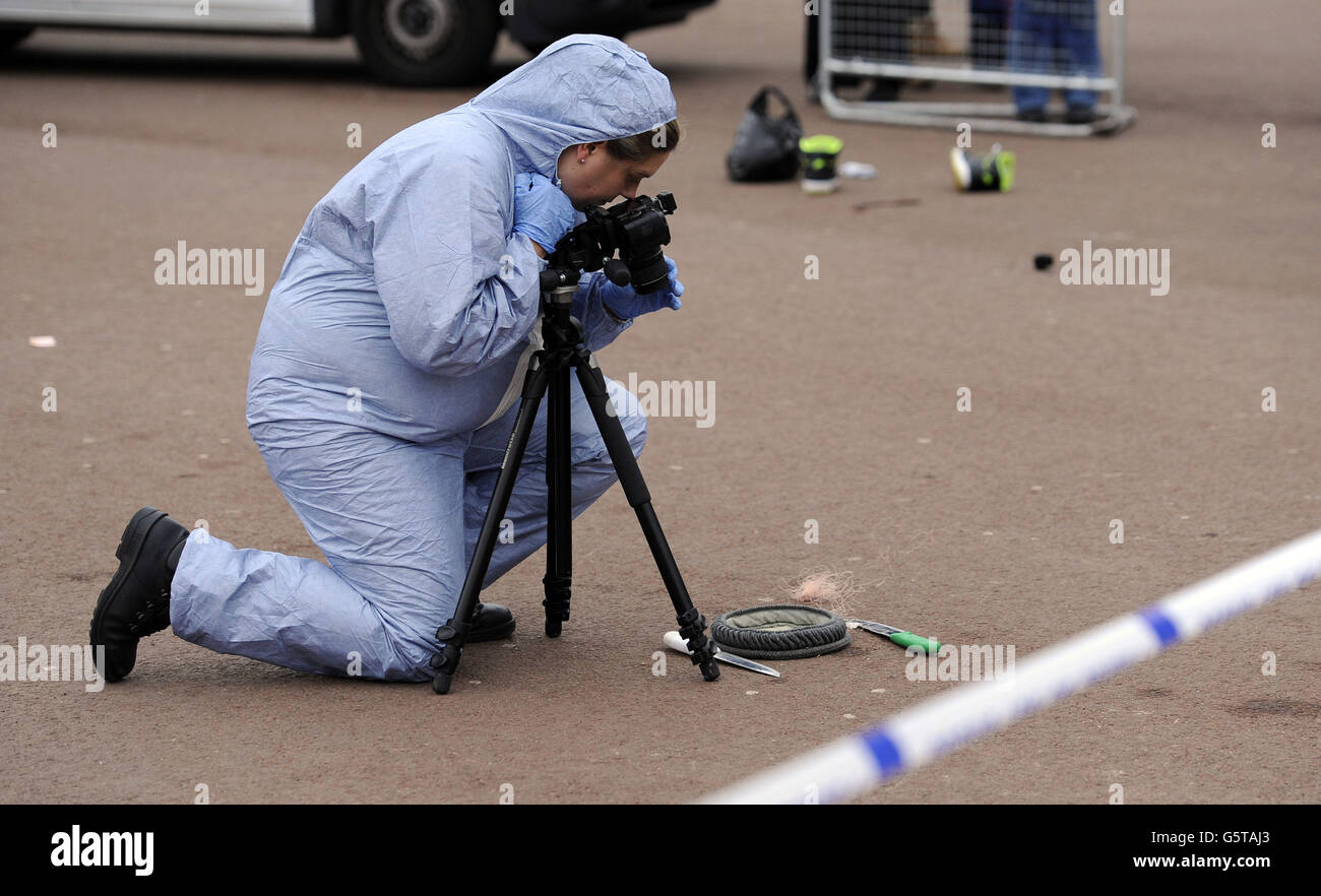 Une scène de crime officier documente des preuves de la scène entre le Queen Victoria Memorial et Buckingham Palace où la police a soumis un suspect à un taser qui était en possession de deux couteaux. Banque D'Images
