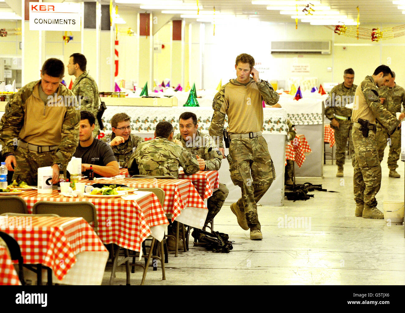 Le Prince Harry ou tout simplement le Capitaine Wales, connu dans l'Armée britannique, avec son équipage dans le DFAC (Dining Facility), au Camp Bastion, dans le sud de l'Afghanistan, où il sert comme pilote d'hélicoptère Apache/Gunner avec 662 corps d'aviation de l'Armée SQD, De septembre 2012 pour quatre mois jusqu'à janvier 2013. 11/12/2012. Banque D'Images