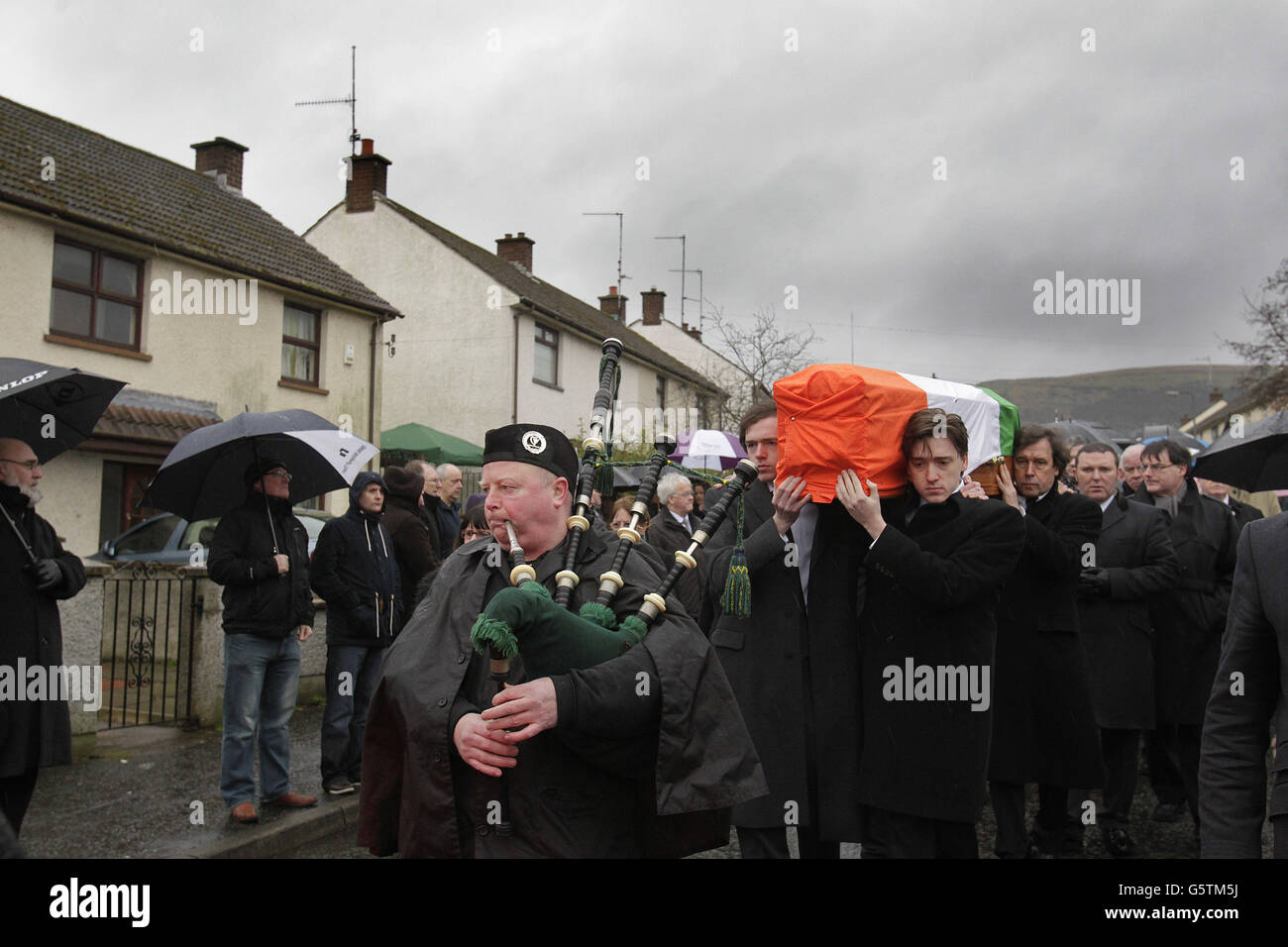 Le cercueil de Dotours Price est transporté de sa maison familiale Slieveglion Drive à Andersontown West Belfast par ses deux fils Danny et Oscar à l'avant et son ex-partenaire acteur Stephen Rea (à l'arrière droite) à l'église St Agnes, puis sur le cimetière de Milltown pour l'enterrement. Banque D'Images