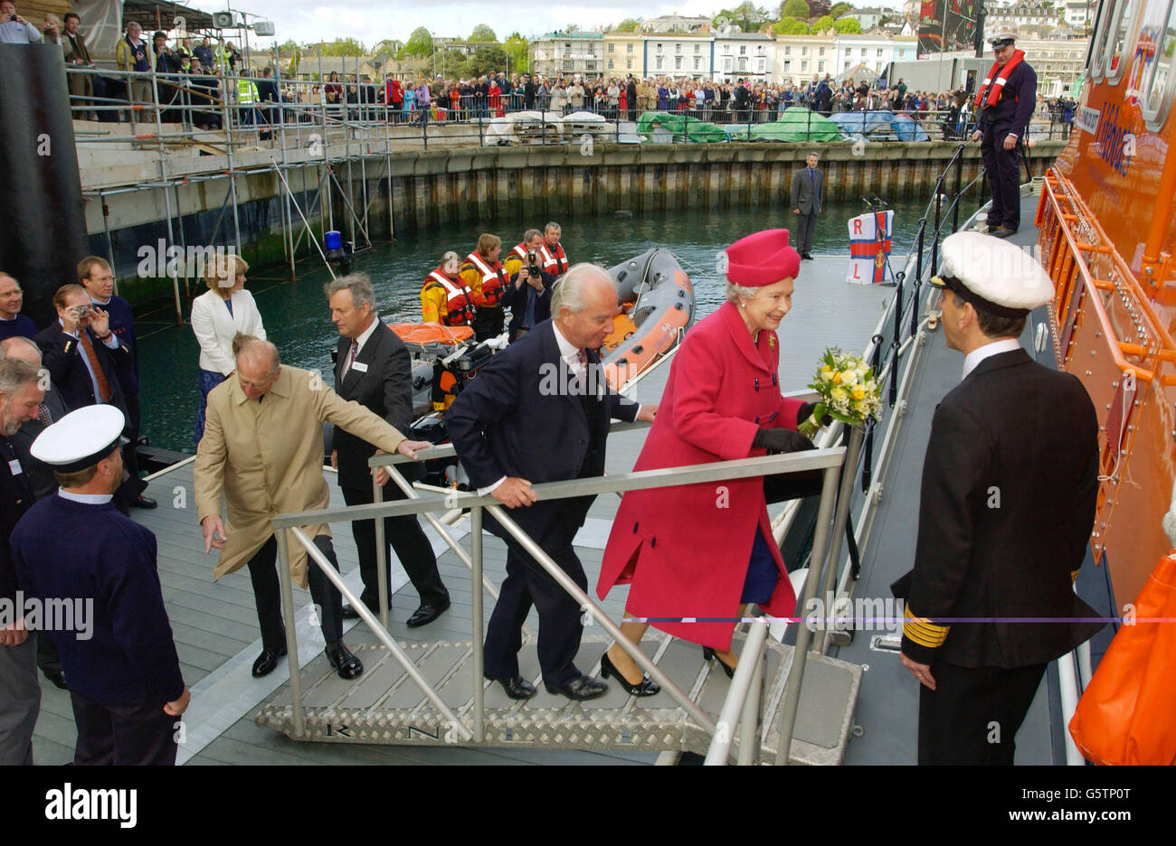 La reine Elizabeth II et le duc d'Édimbourg (manteau beige) montent à bord du canot de sauvetage Richard Cox Scott dans le port de Falmouth après l'avoir officiellement nommé au port maritime de Cornouailles. Banque D'Images