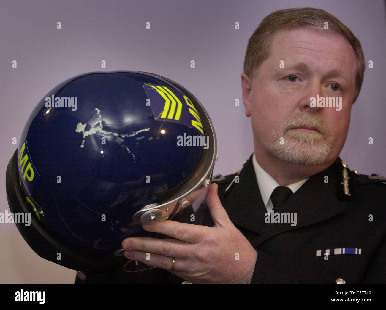 Le commissaire adjoint de la police métropolitaine, Ian Blair, porte un casque porté par un policier qui a été endommagé lors de troubles dans le sud-est de Londres après que le Millwall football Club ait manqué sa promotion à Birmingham City. Banque D'Images