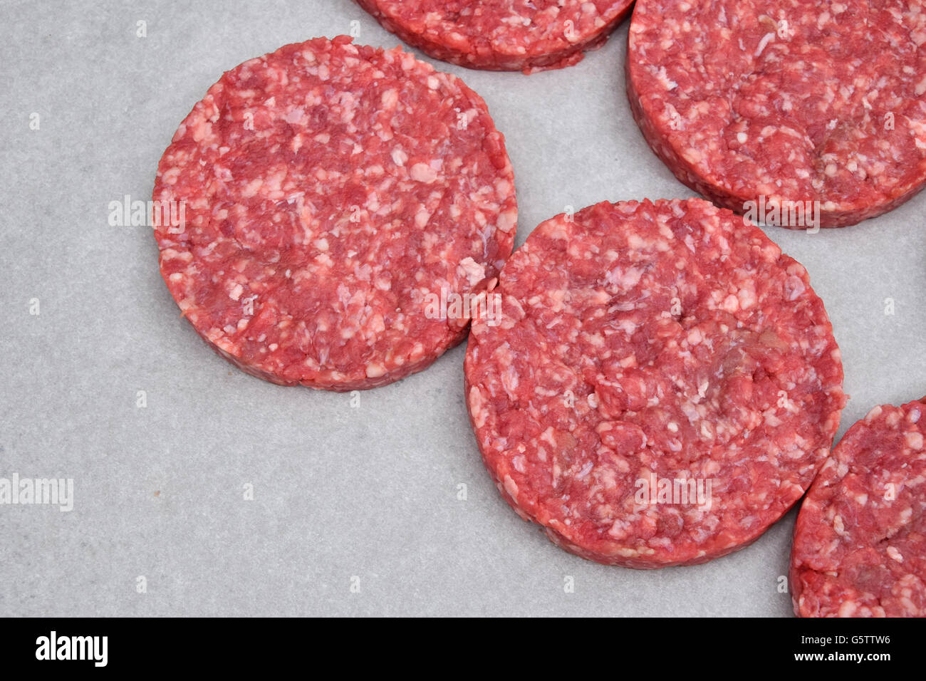 La viande rouge des hamburgers pour hamburgers de viande hachée de boeuf ou porc sur du papier parchemin blanc prêt pour la cuisson Banque D'Images