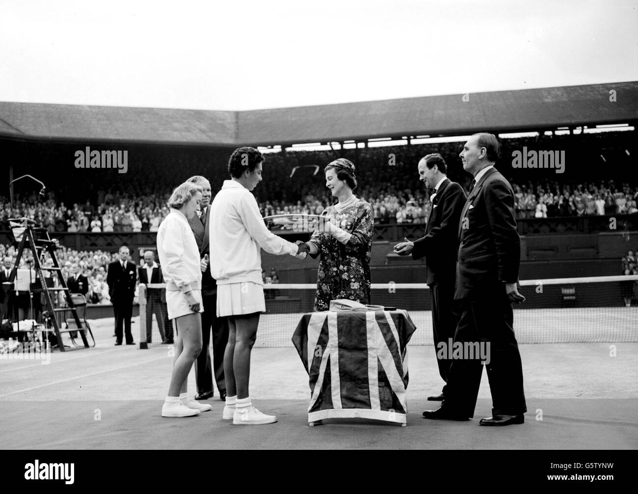 La duchesse de Kent présente le trophée à Miss Althea Gibson après la finale féminine sur le terrain central de Wimbledon. On y regarde Miss Angela Mortimer, la joueuse de la coupe britannique Wightman, que Miss Gibson a battu 8-6 6-2 pour conserver le titre. Banque D'Images