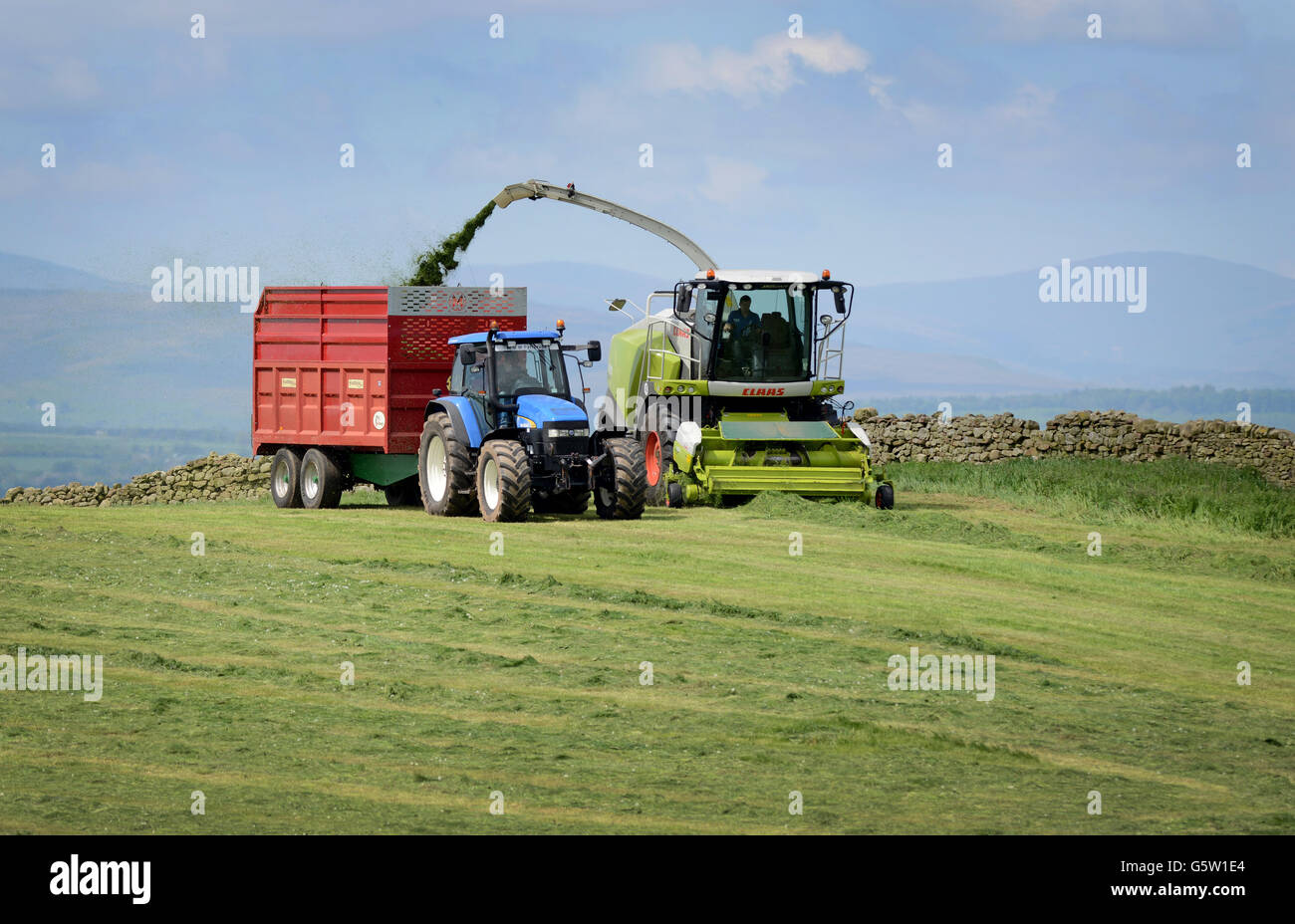 Les agriculteurs pour l'ensilage coupe herbe à Brampton, Cumbria, Angleterre. Banque D'Images