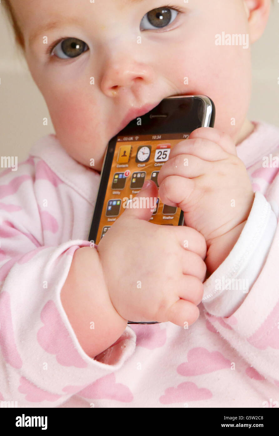 STOCKER bébé. Un bébé tenant un iPhone 3GS d'Apple. Banque D'Images