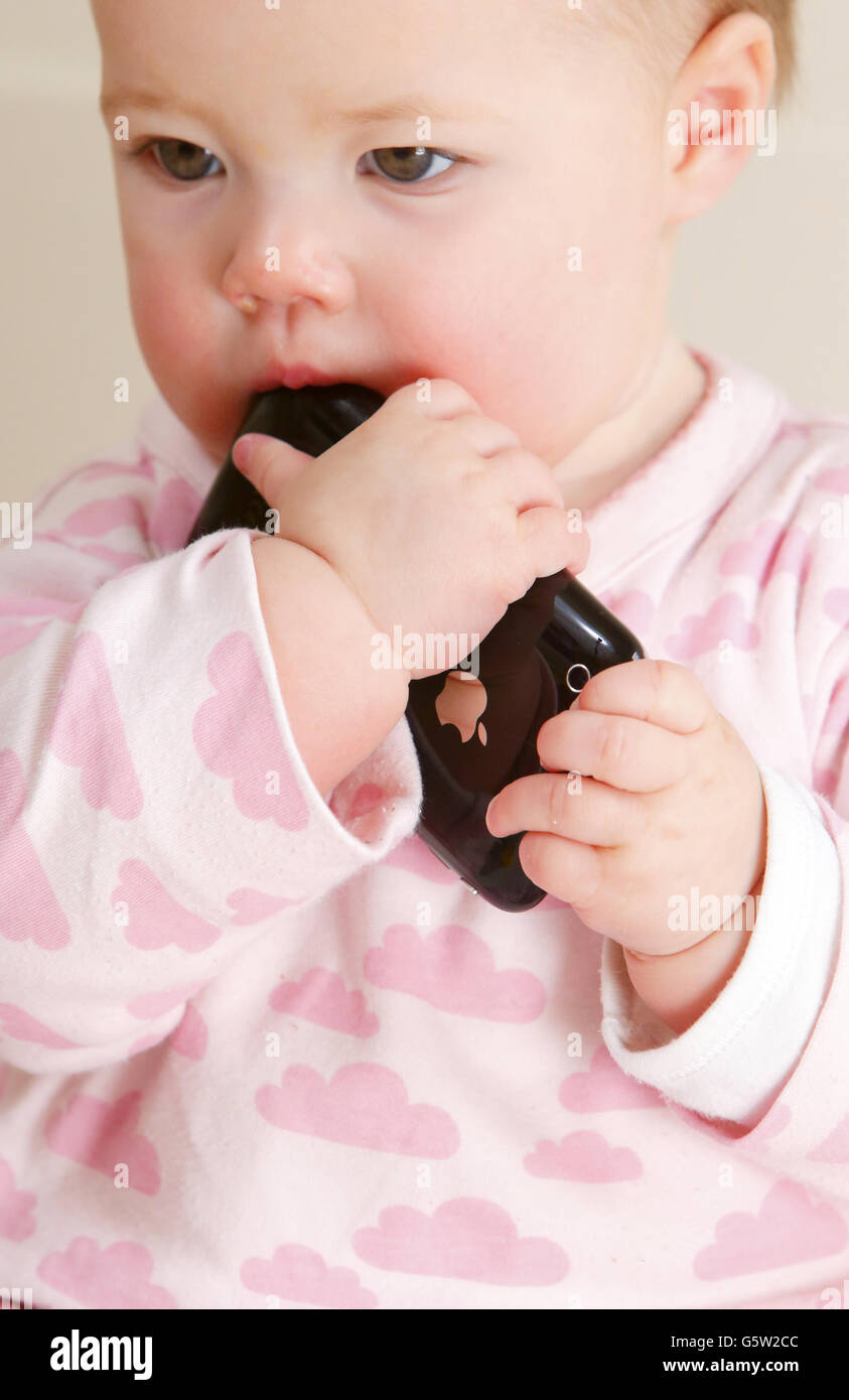 STOCKER bébé. Un bébé tenant un iPhone 3GS d'Apple. Banque D'Images