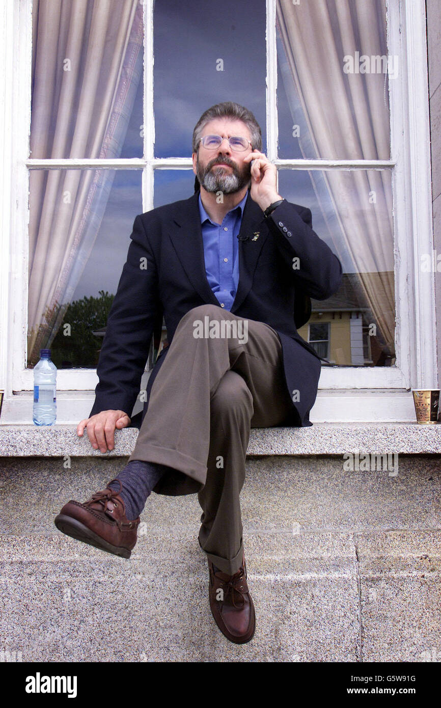 Le président de Sinn Fein Gerry Adams est informé par téléphone que Martin Ferris a été élu au Co Kerry, alors qu'il était assis à l'extérieur du centre des comptes du RDS à Dublin. Sinn Fein sont bien de vote avec trois sièges sécurisés. Banque D'Images